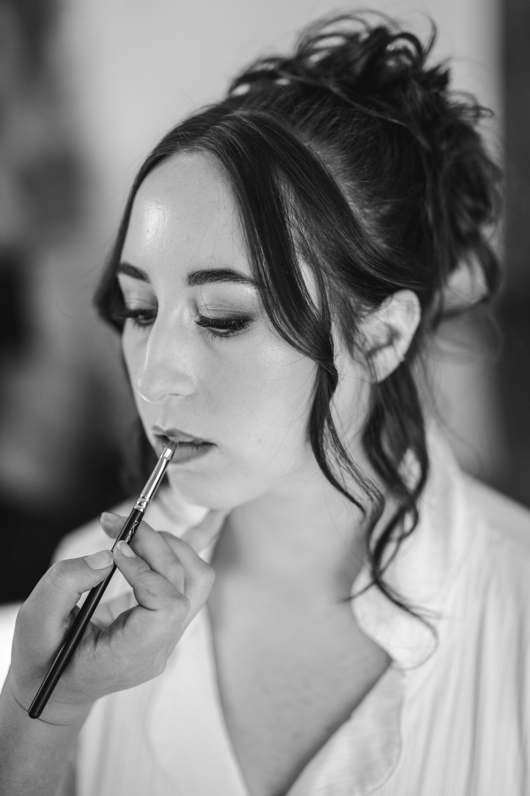 bride gets lipstick put on during getting ready photos during elopement day in colorado
