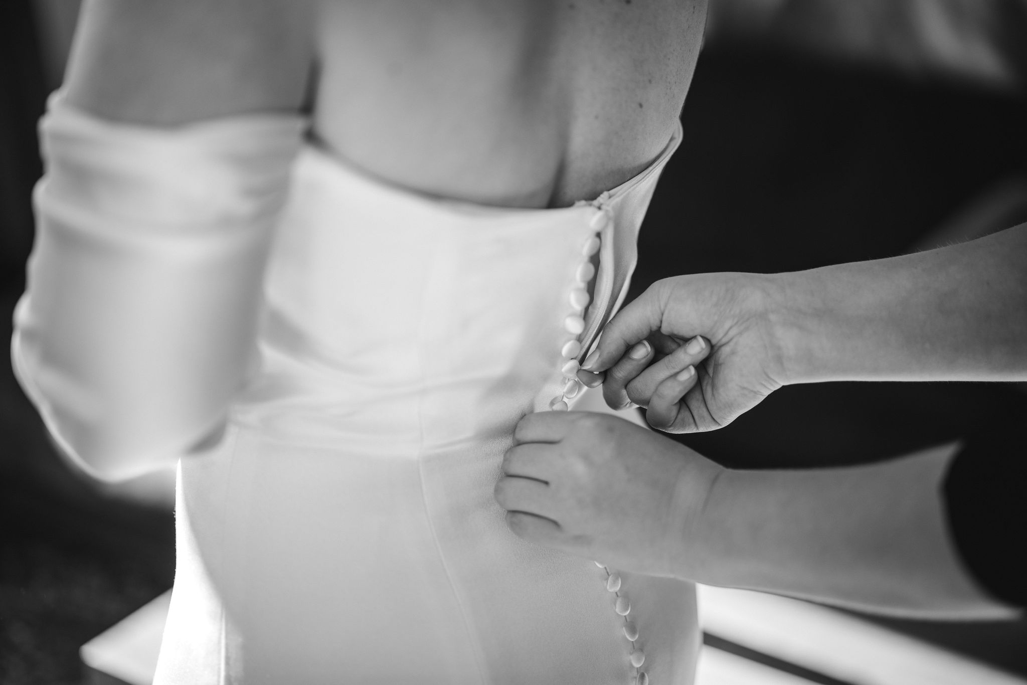 close up of bride getting dress zipped up by her child on her elopement day.