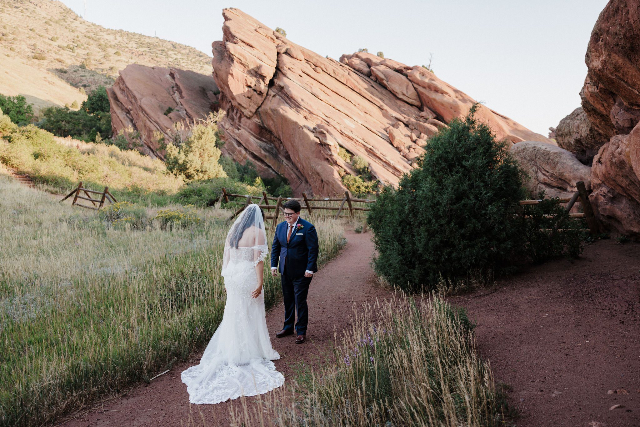 two brides smile big at each other during their wedding day first look