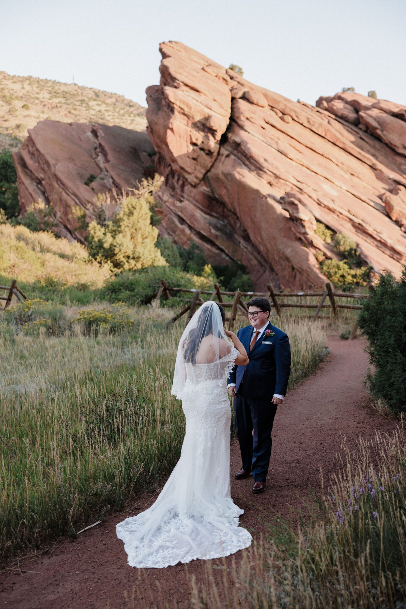 two brides smile and look at each other during their elopement in red rocks park