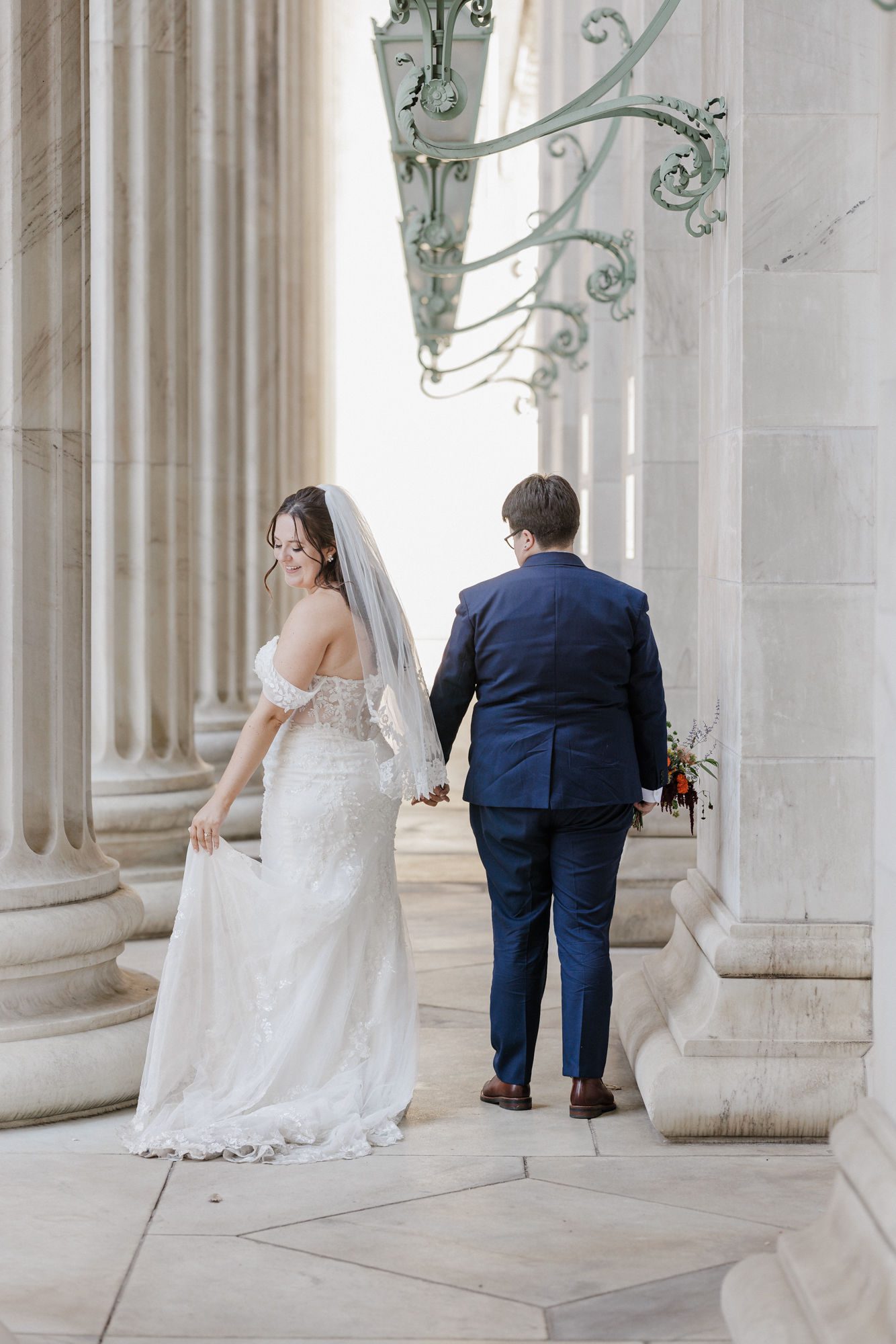two brides walk through byron white courthouse in Denver as part of their fun second wedding ideas