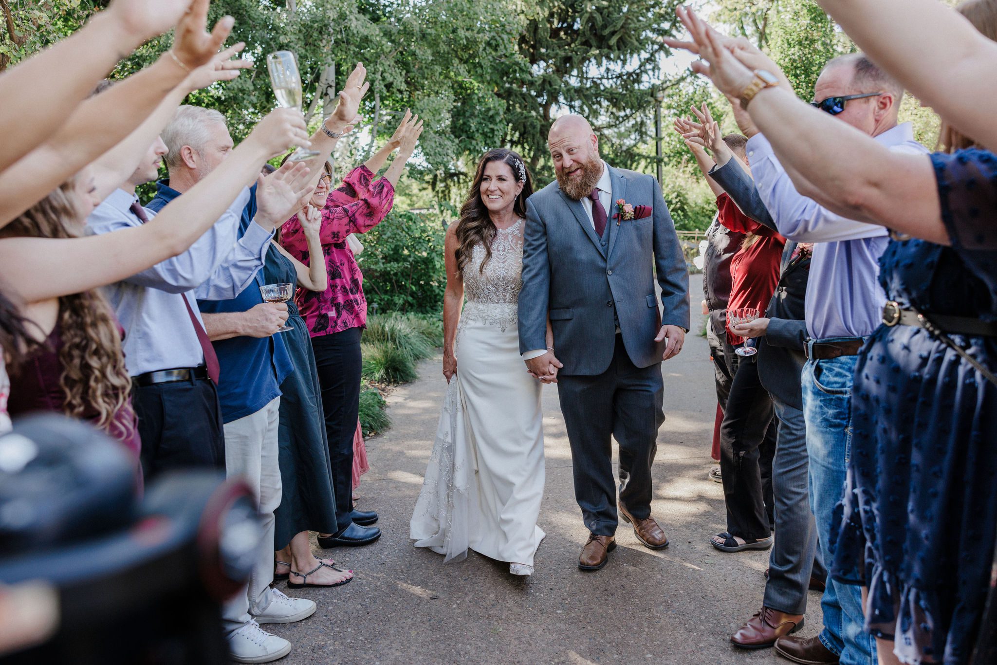 bride and groom walk down aisle of people celebrating during their second wedding