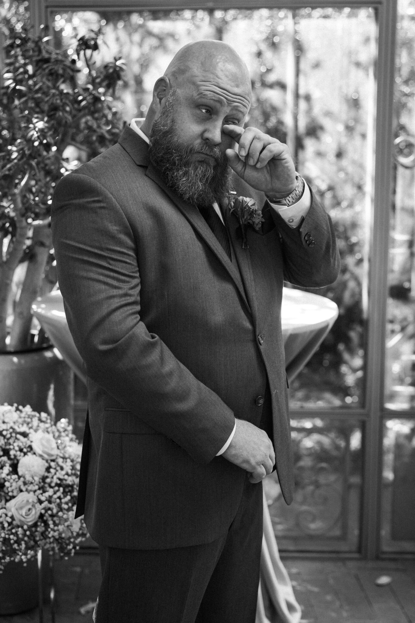 groom wipes tear from his eye after seeing his bride walk down the aisle
