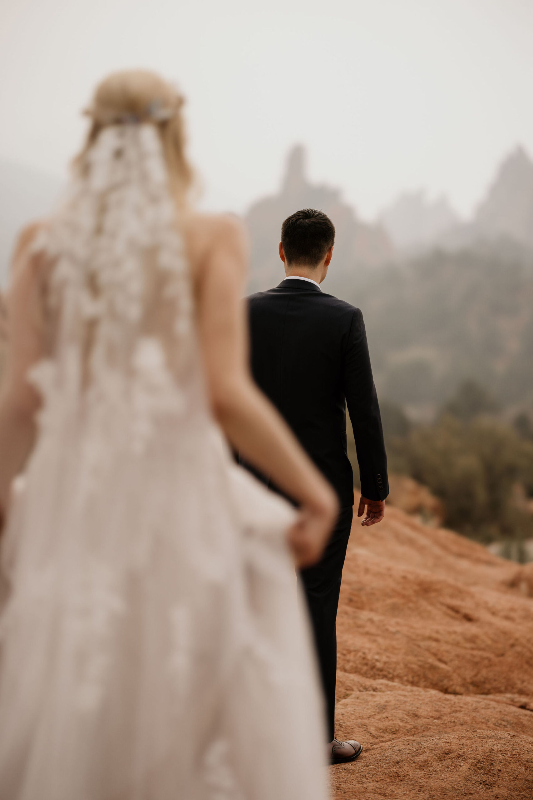 bride stands behind groom during elopement first look in colorado springs.