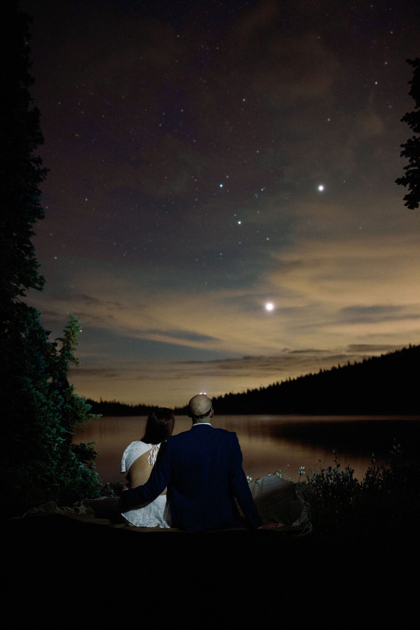 after choosing an adventure colorado elopement package, bride and groom sit on a rock and look at the stars overhead.