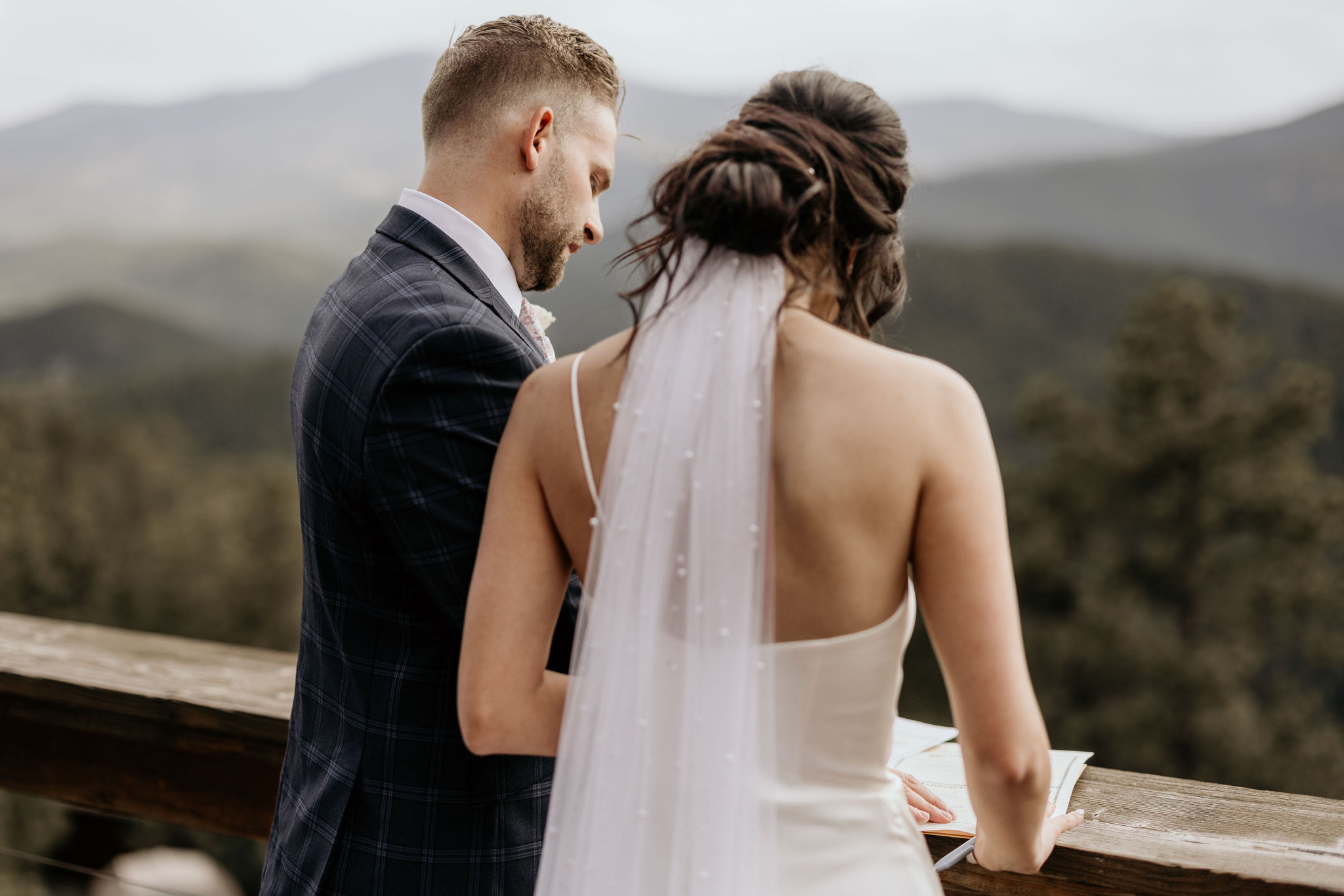 bride and groom sign marriage license on the deck of a colorado airbnb.