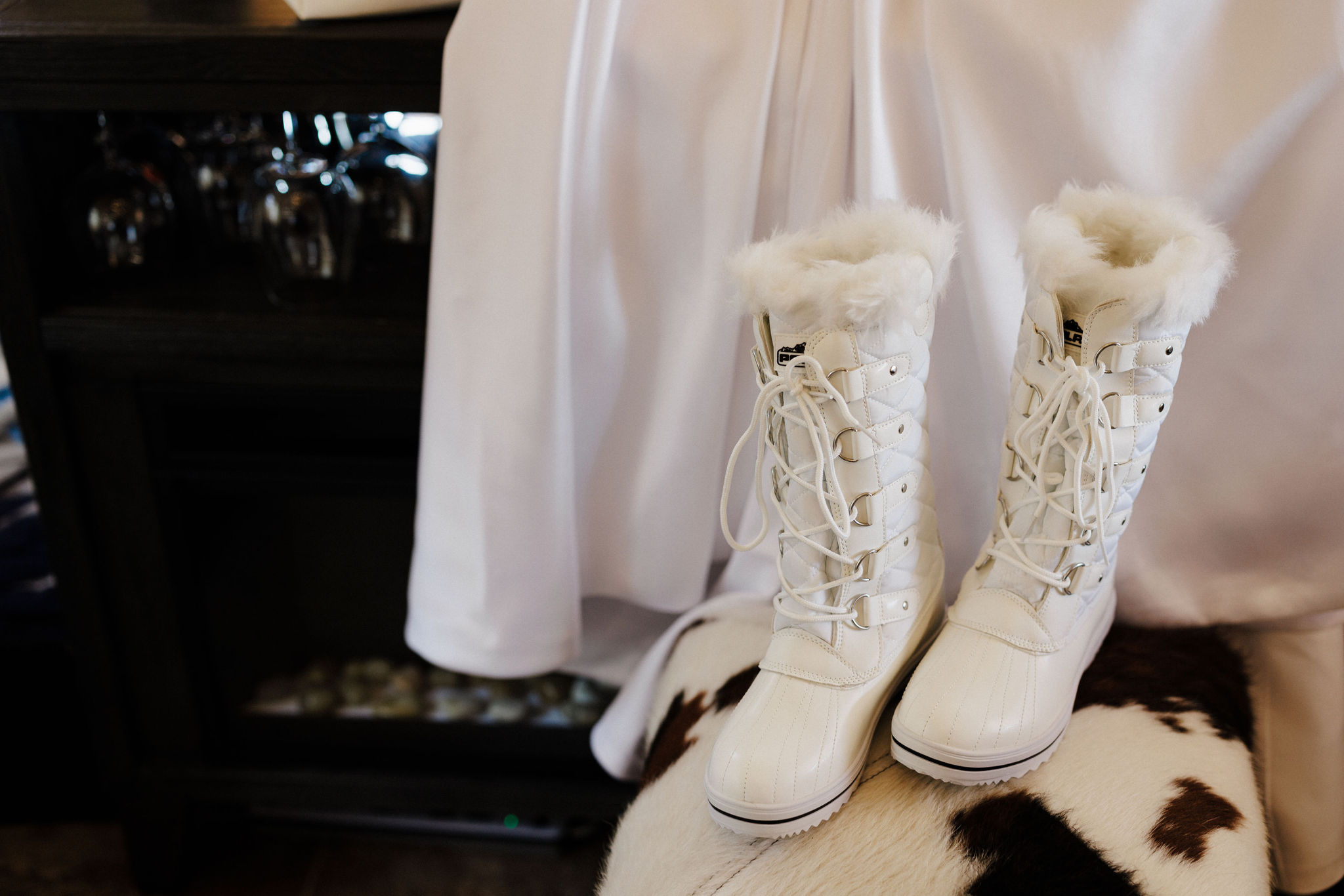 brides boots and wedding dress sit in colorado airbnb