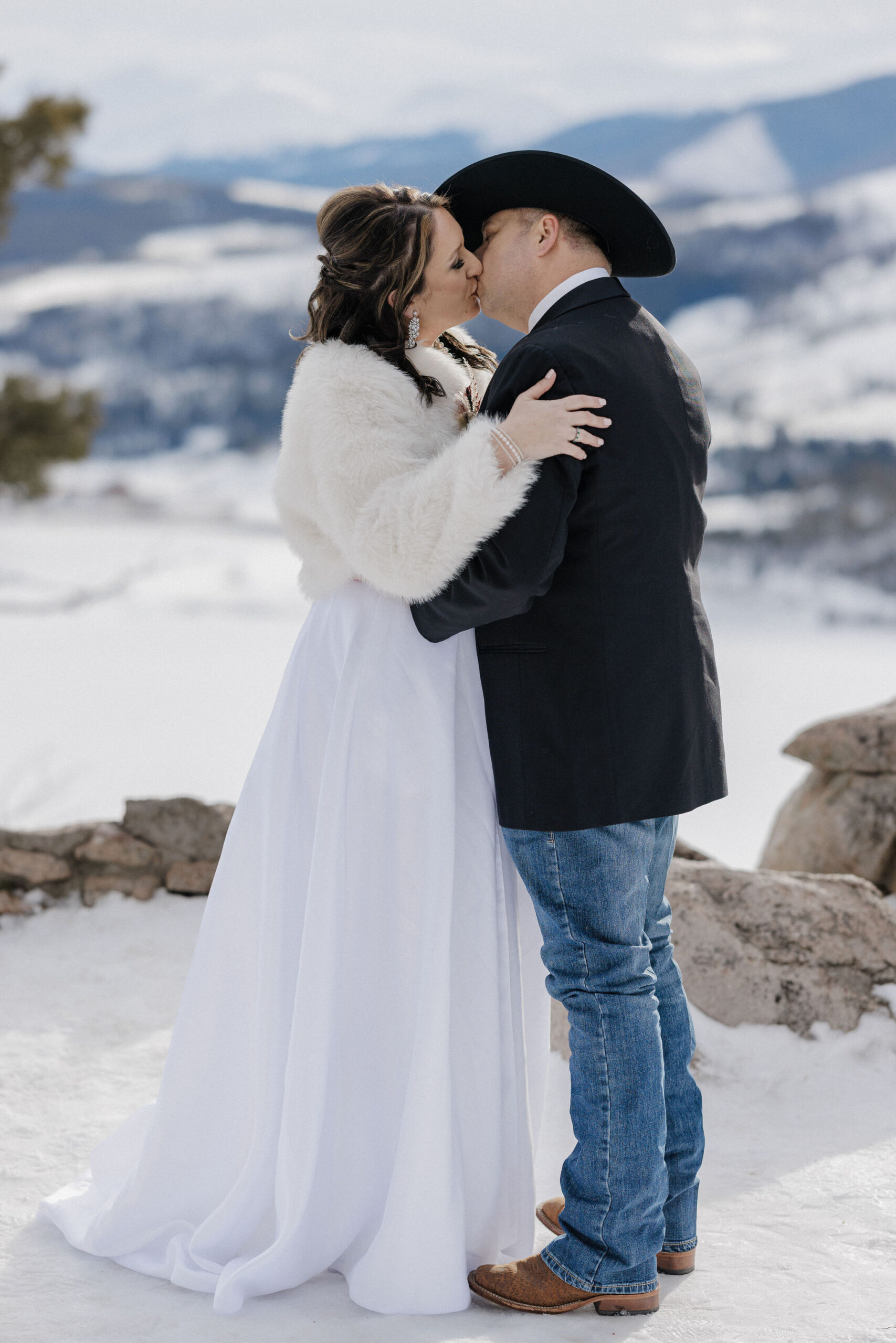 Bride and groom share first kiss during Colorado mountain elopement.