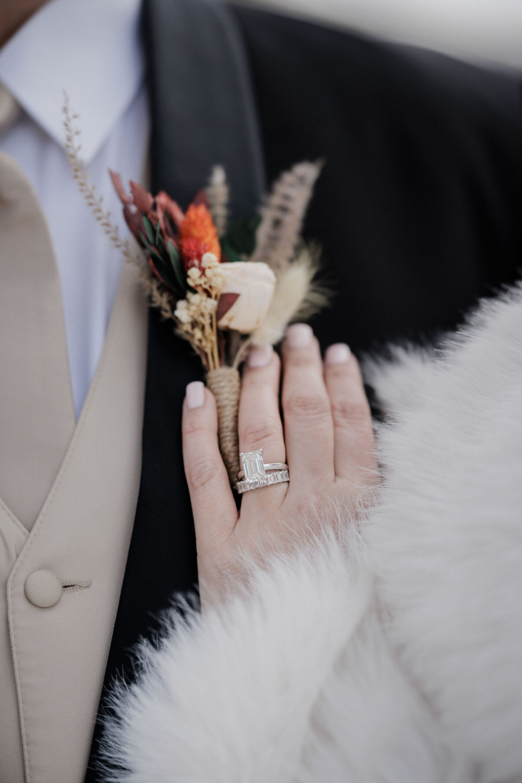 close up image of brides hand and wedding ring sitting on grooms chest