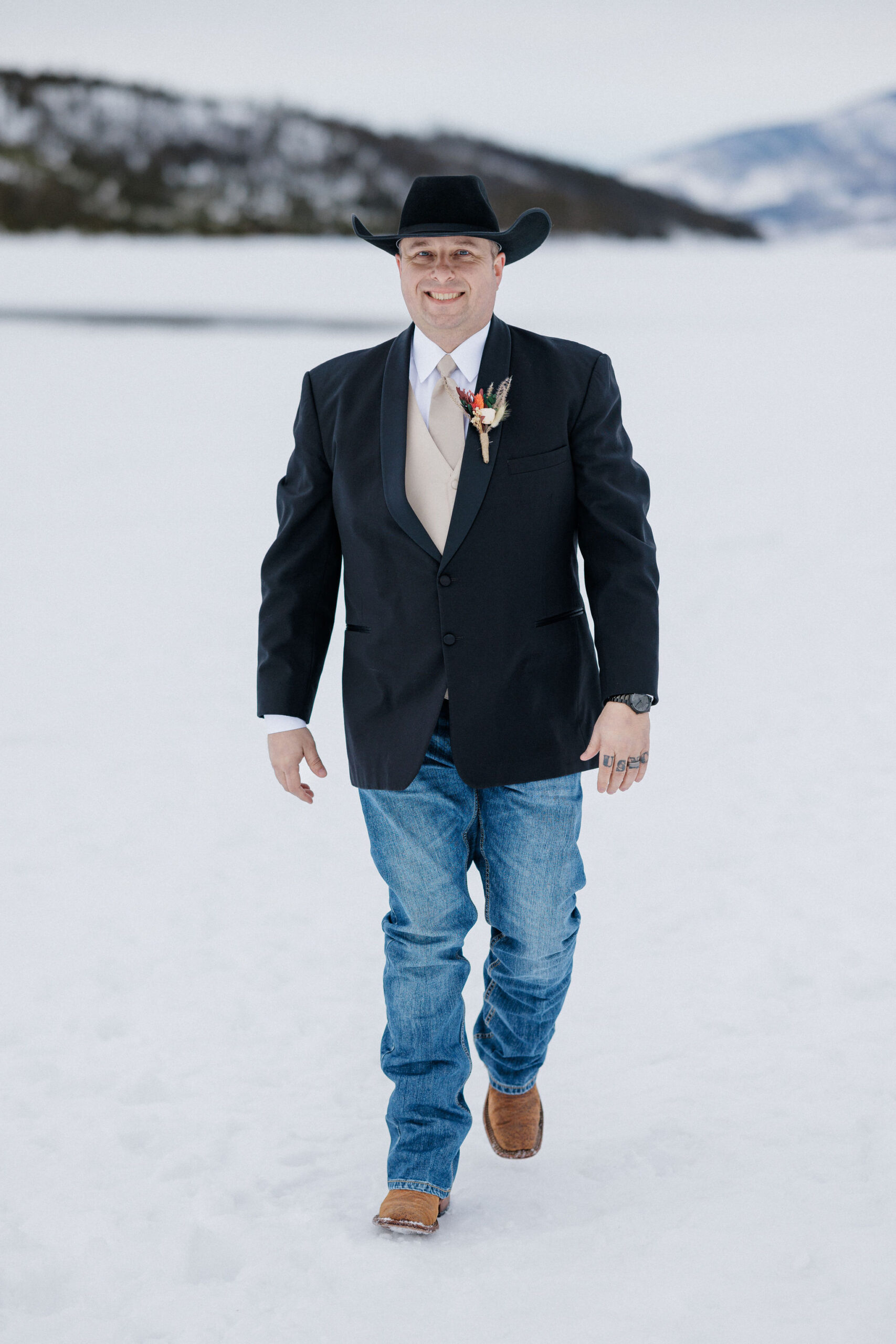 groom walks by lake dillon during wedding photos