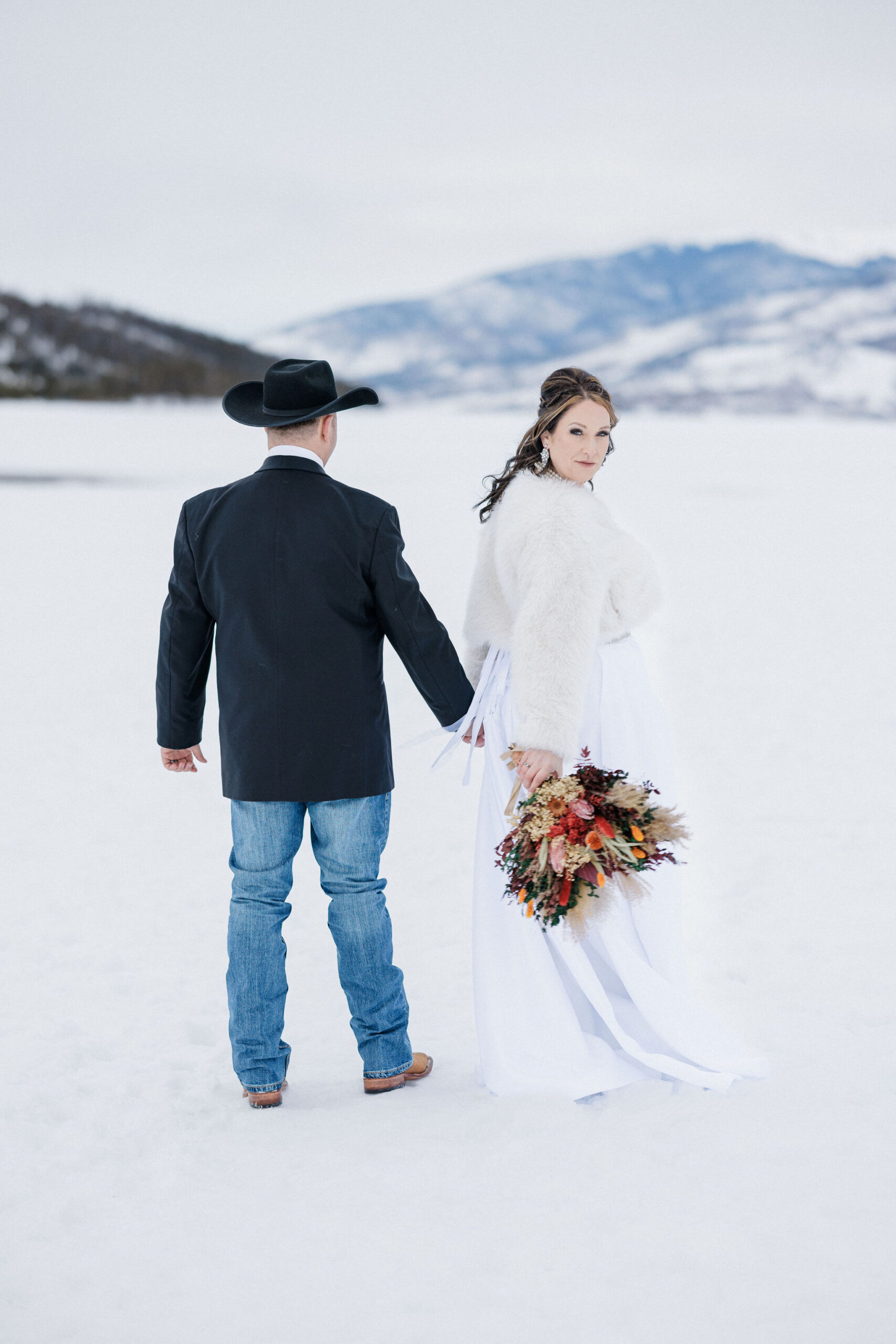 Bride looks back at colorado elopement photographer during elopement photos with her husband