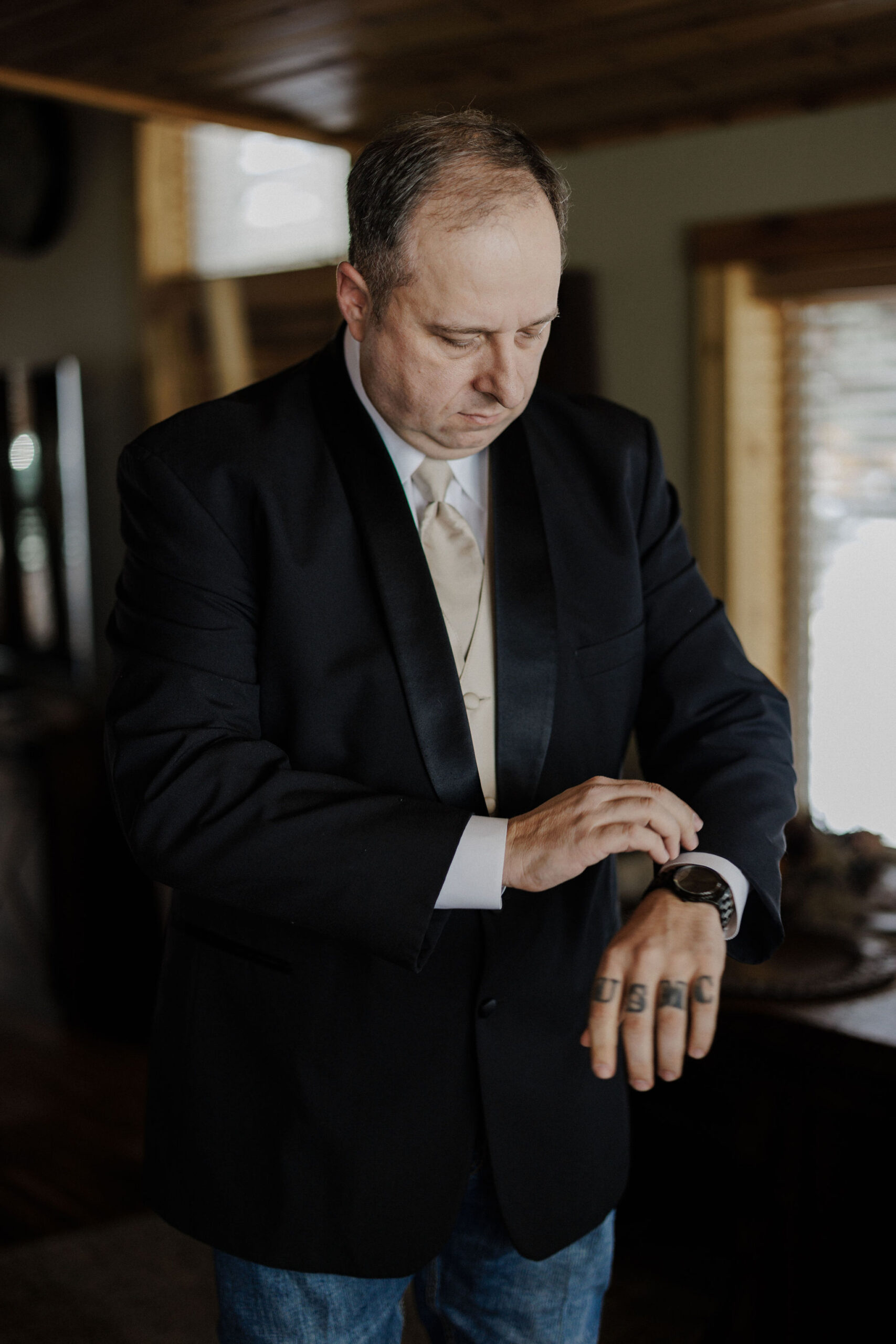 groom gets ready for wedding and puts jacket on