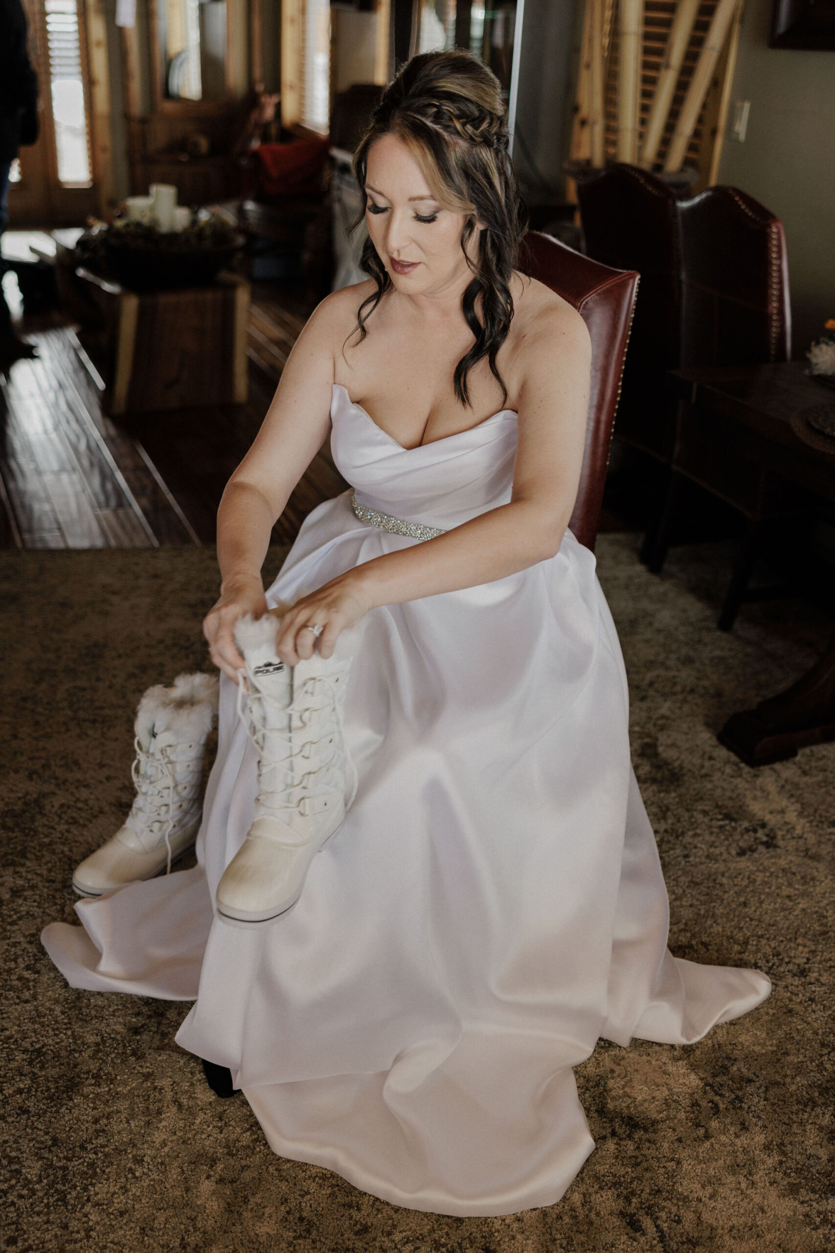 bride puts snow boots on for winter sapphire point elopement.
