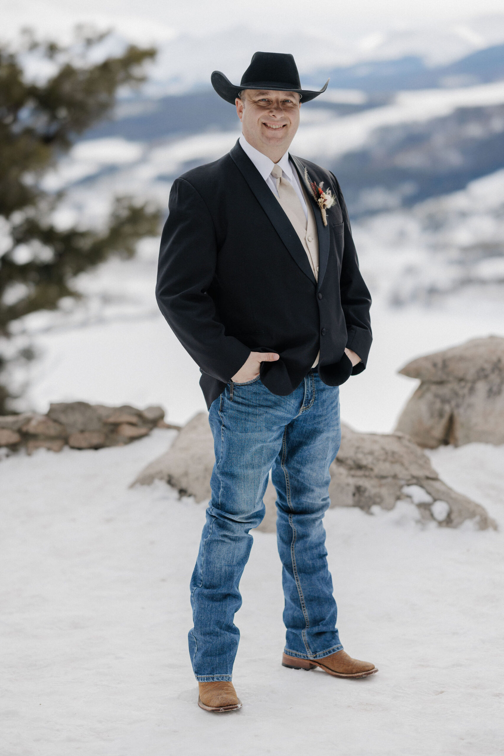 groom smiles as he takes wedding photos in colorado