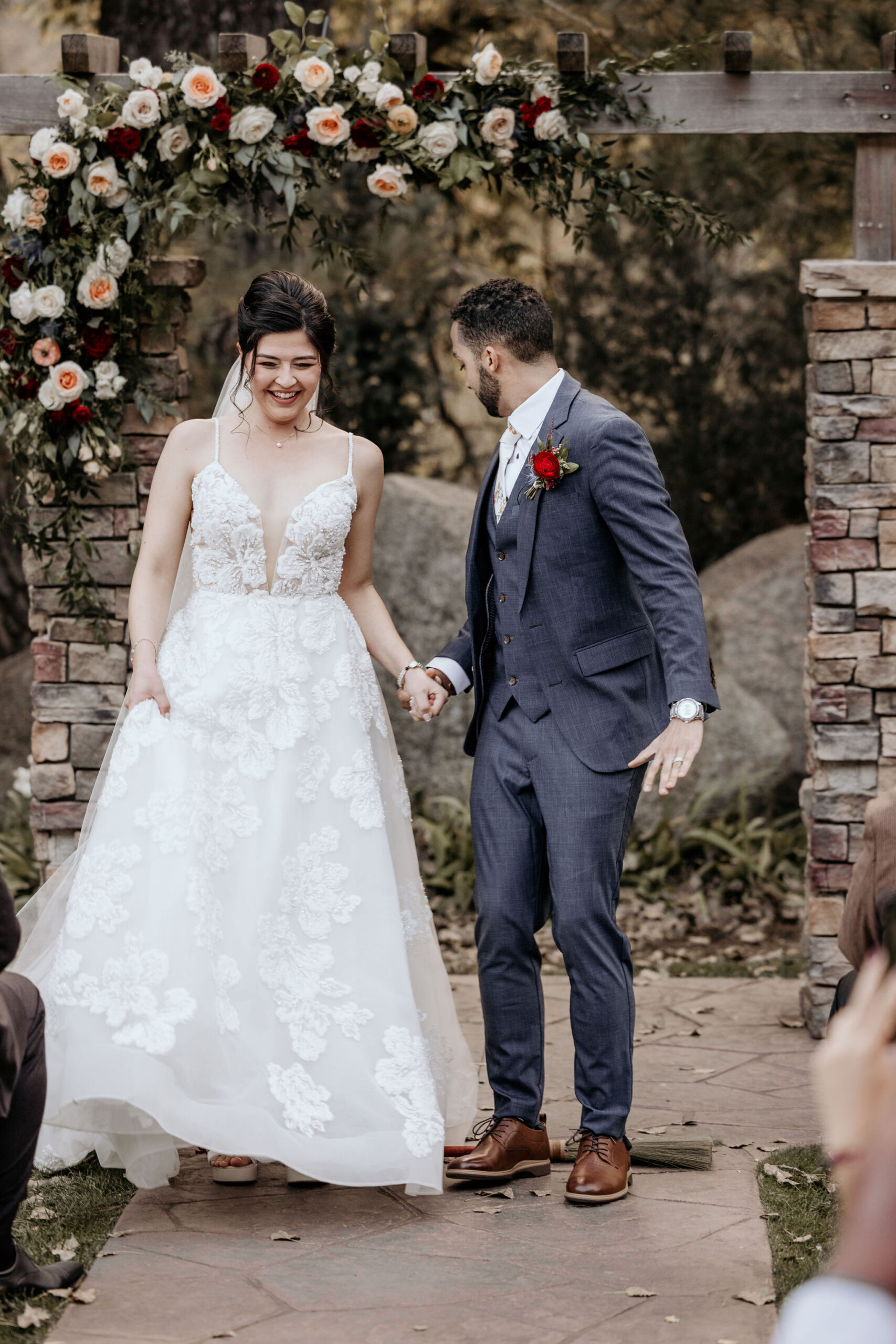 bride and groom jump over broom during self-solemnizing wedding in colorado