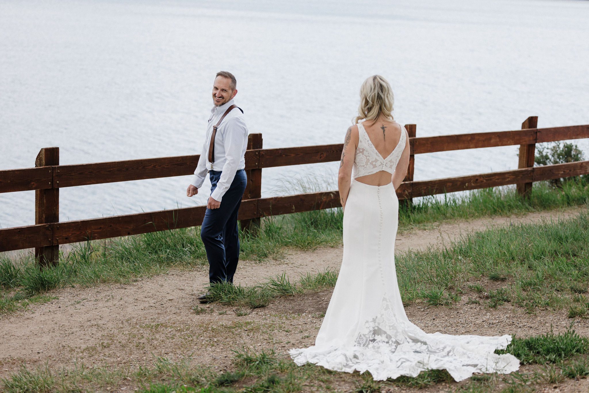 bride stands behind groom as he turns around during their first look idea for their wedding