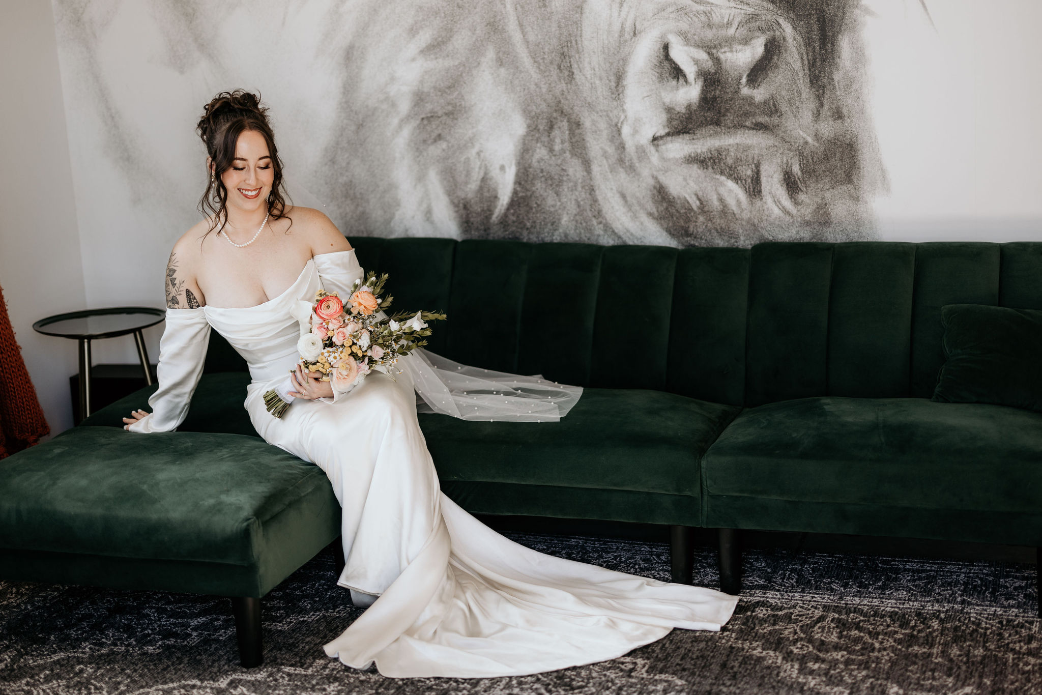 bride sits on green couch during luxury elopement at airbnb