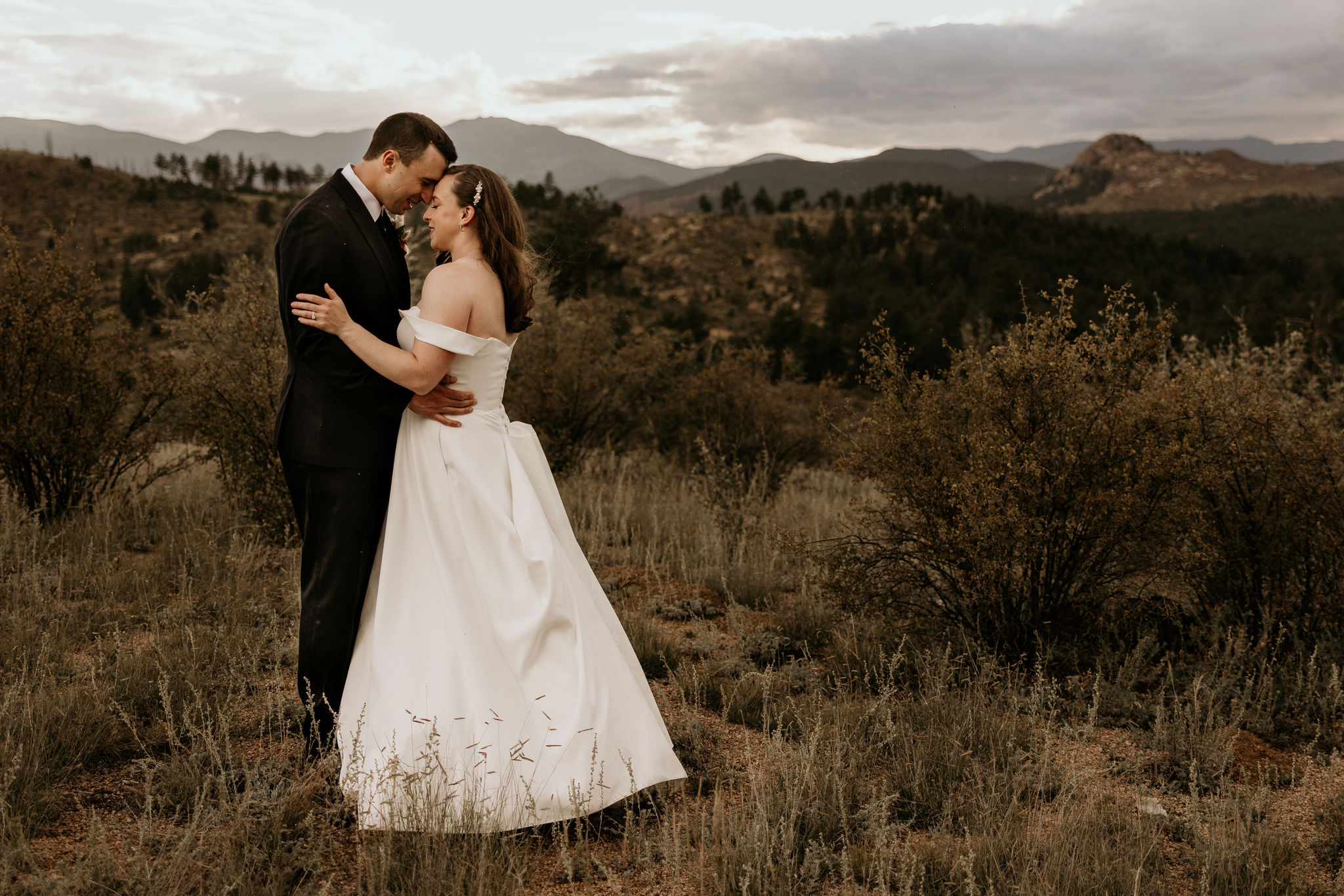 bride and groom hug during wedding photos in the mountains