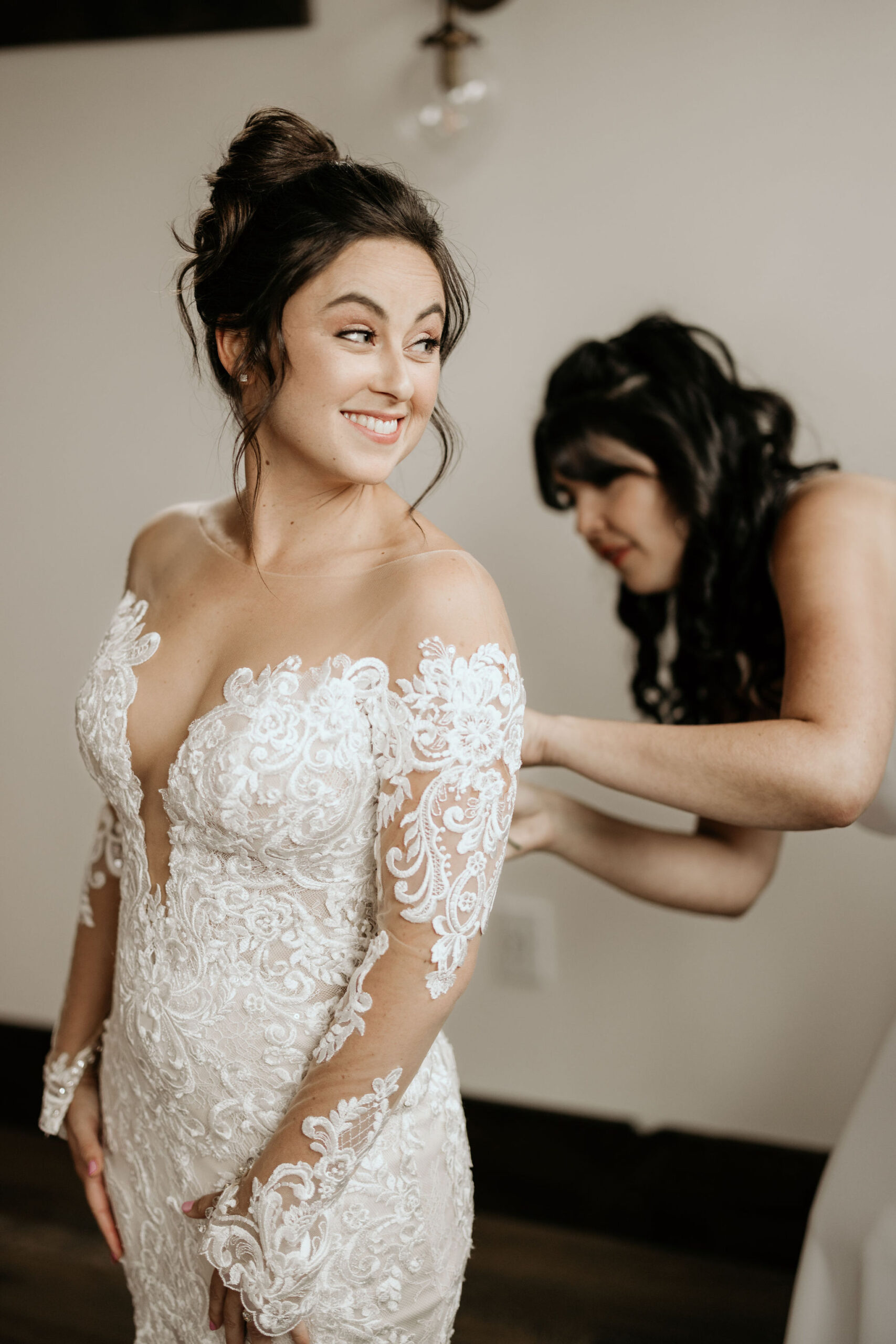 bride has someone help with wedding dress during colorado mountain wedding