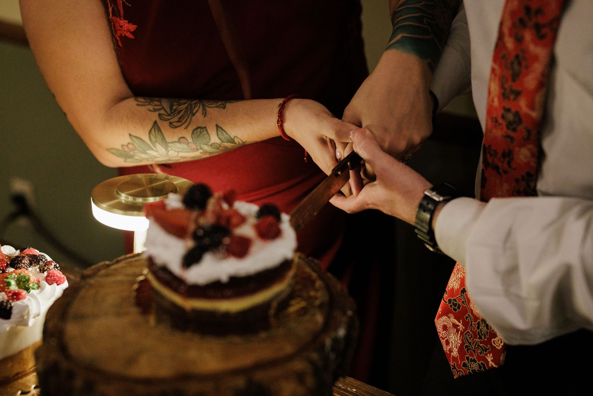 bride and groom cut into elopement cake with custom wedding cake topper