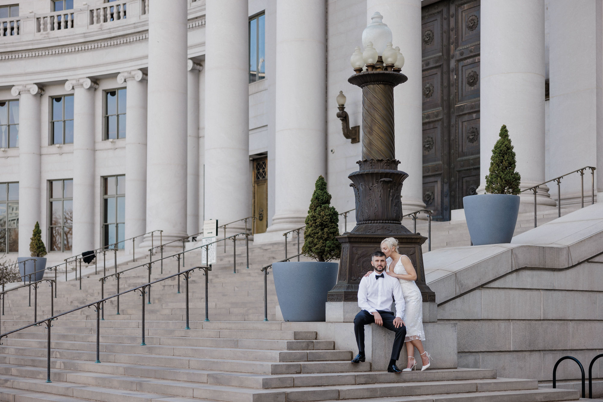 Why Renew Your Wedding Vows? Ideas, Reasons, + How-To: bride and groom sit on the steps of the denver district court house