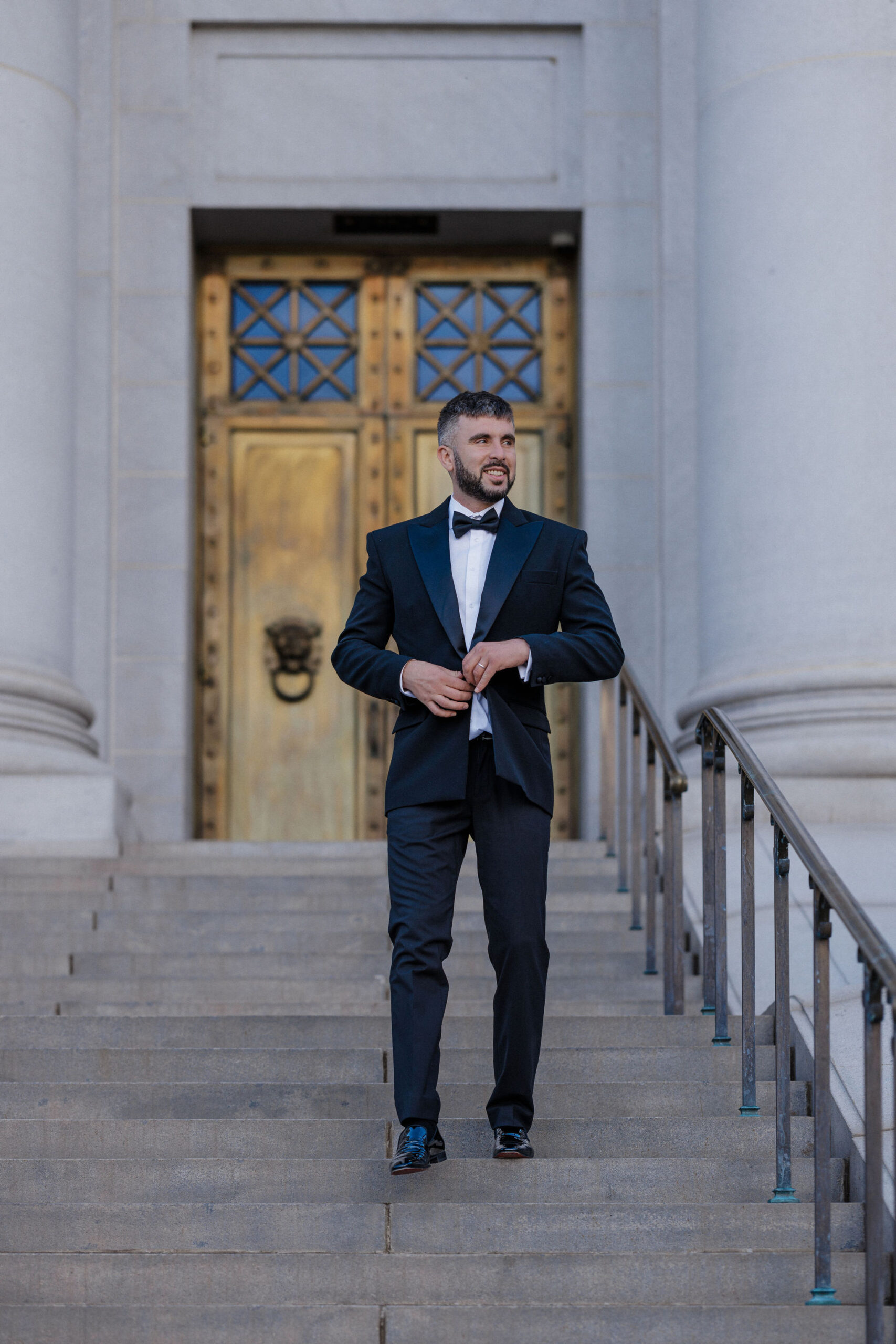 groom walks down steps of denver courthouse during CO elopement