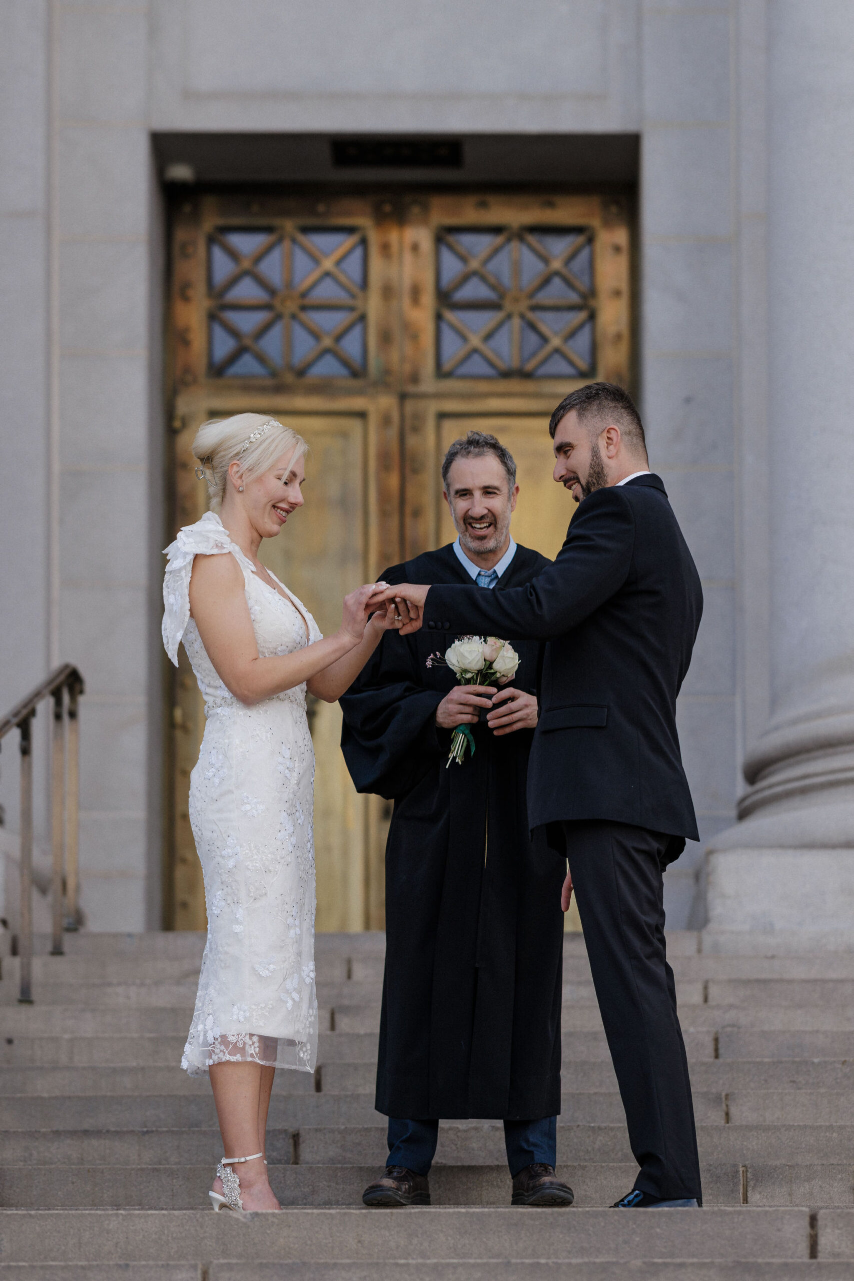 bride and groom put on wedding rings during downtown denver courthouse elopement