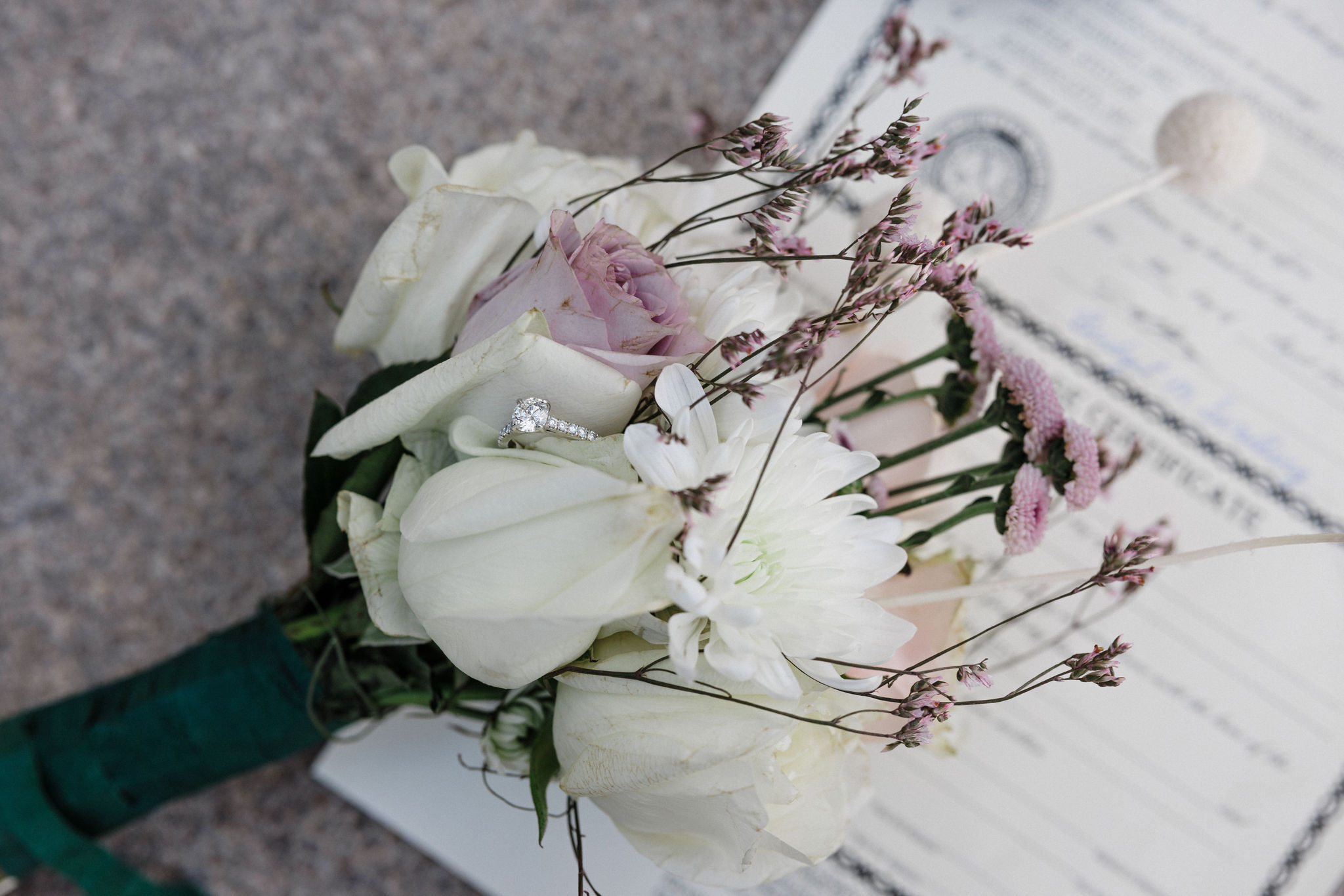 wedding bouquet sits on marriage certificate during courthouse elopement