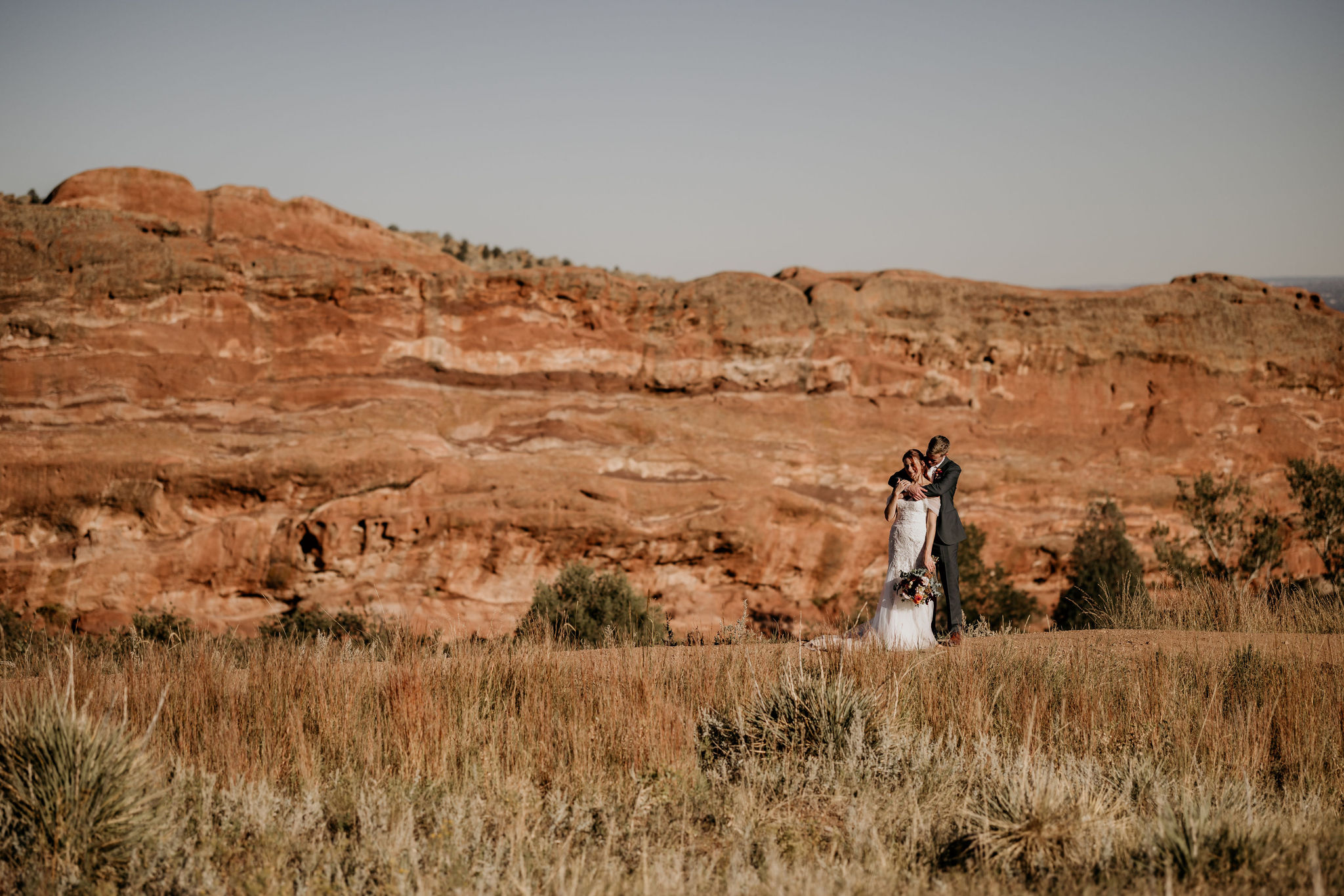 Why Renew Your Wedding Vows? Ideas, Reasons, + How-To: bride and groom walk along trail at red rocks park and Amphitheatre