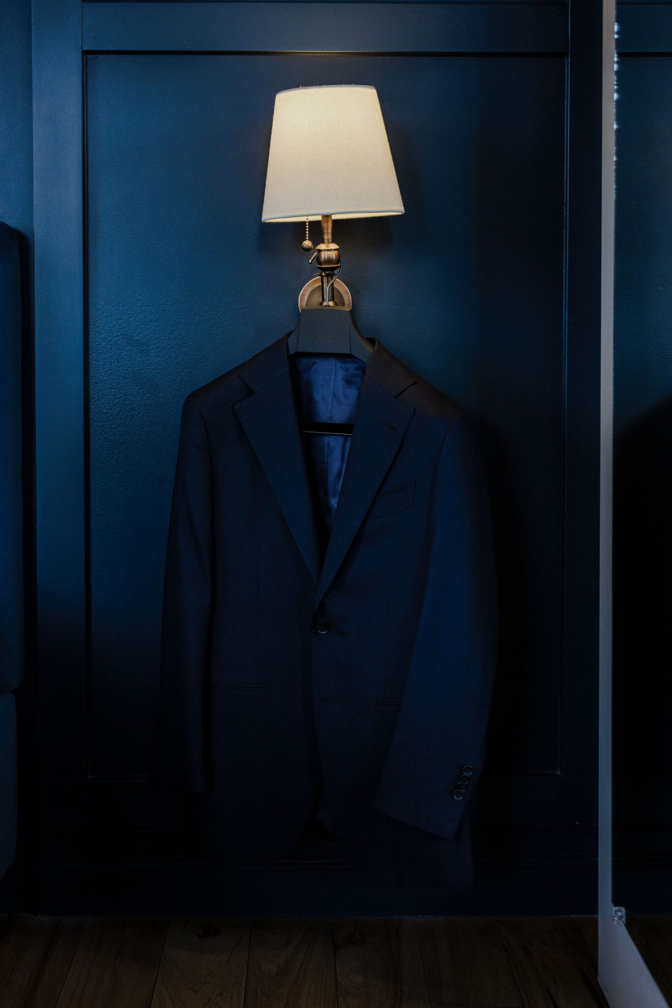 suit hangs on deep blue wall at wedding venue accommodation