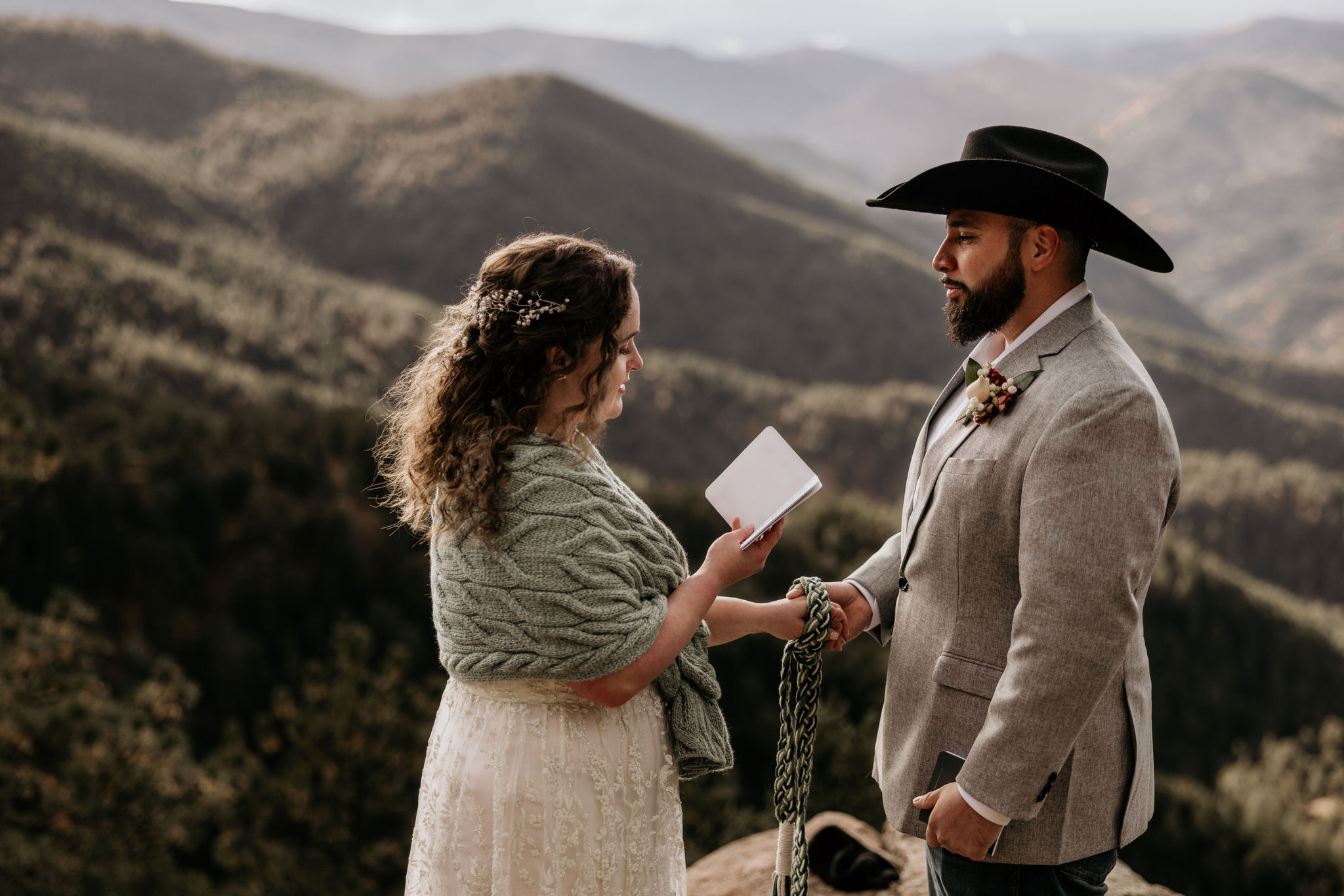 Why Renew Your Wedding Vows? Ideas, Reasons, + How-To: bride and groom read each other their vows overlooking the colorado mountains