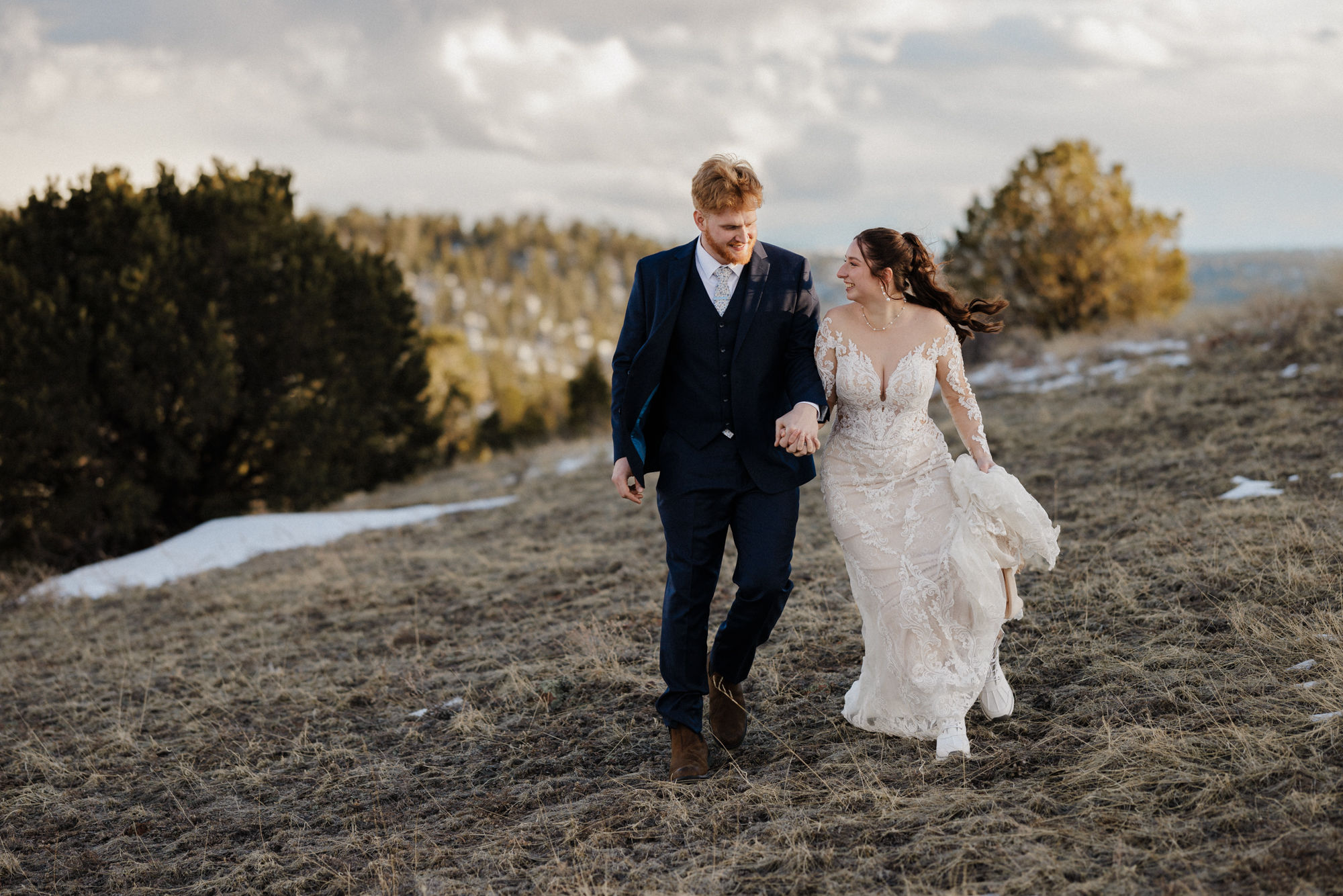 bride and groom walk along mountain at colorado airbnb micro wedding