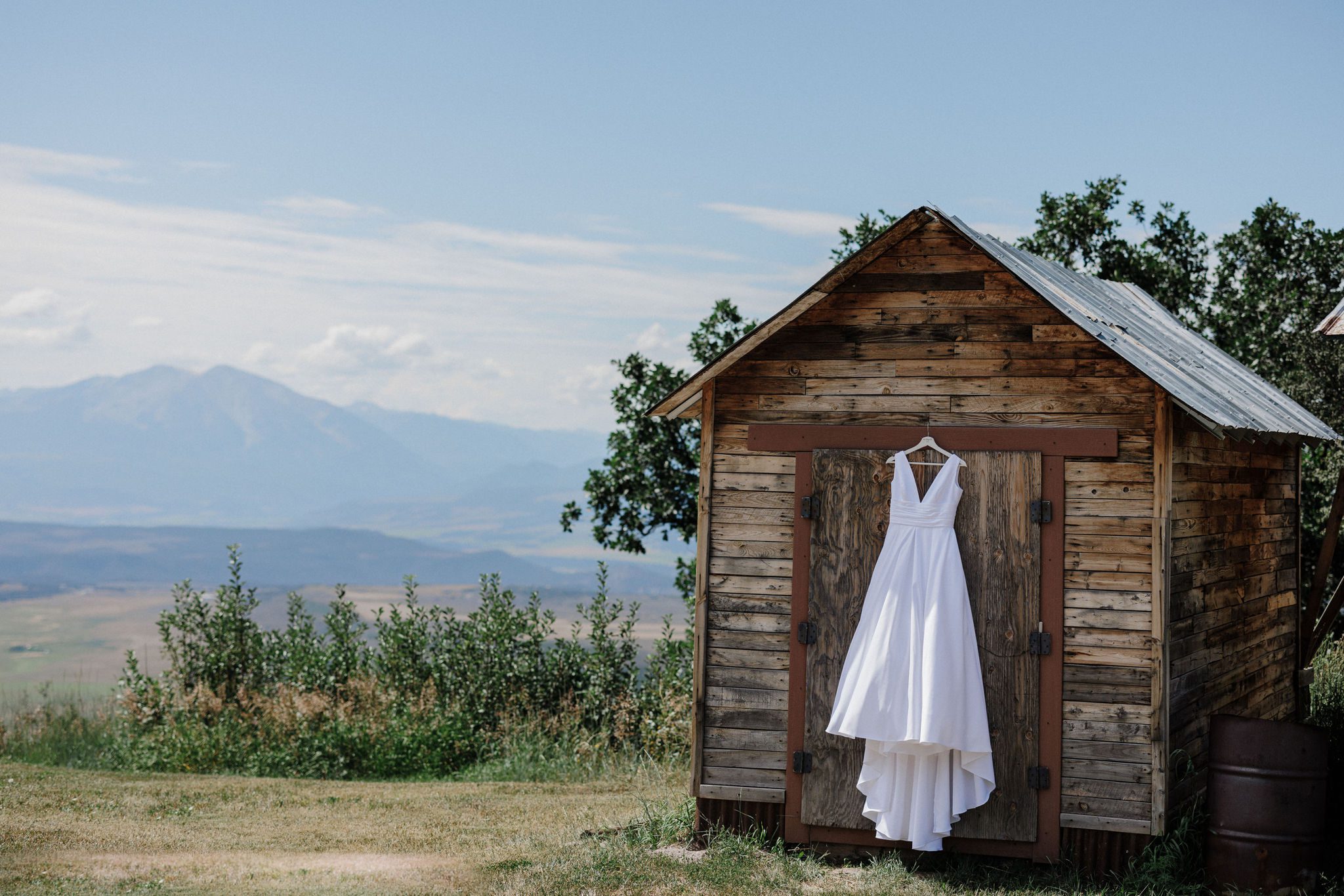 a wedding dress hangs on a shed at a micro wedding accommodation venue in colorado