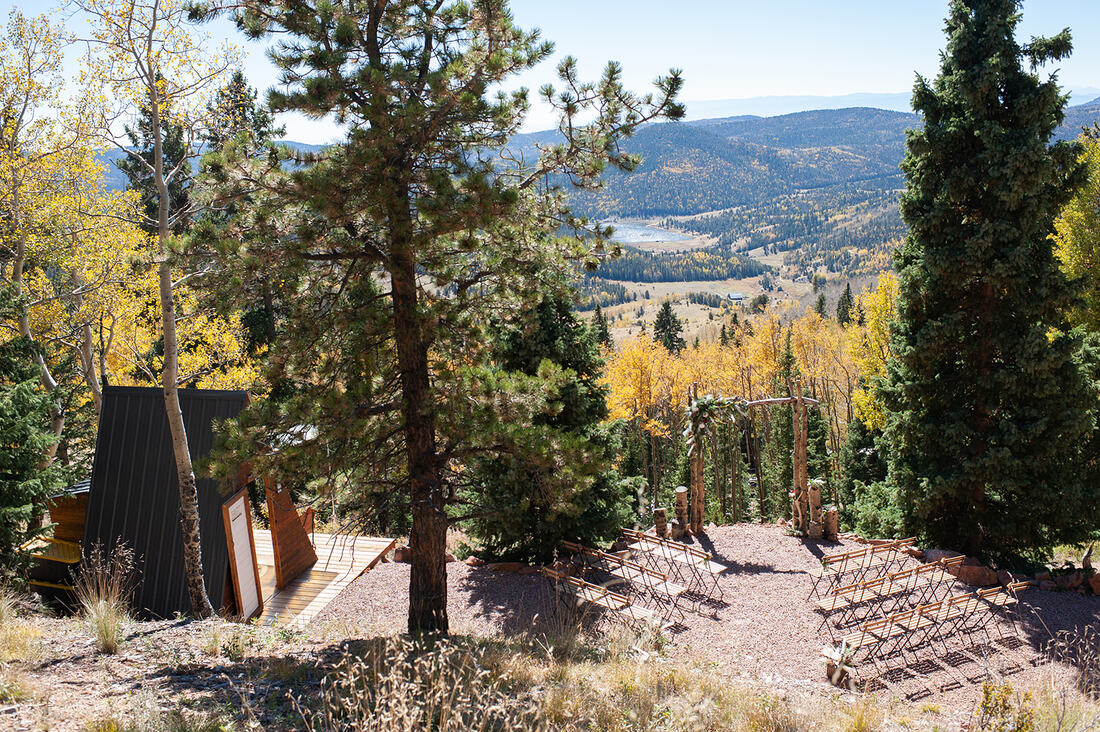 colorado micro wedding venue ceremony set up in the mountains- with cabin lodging on the side.