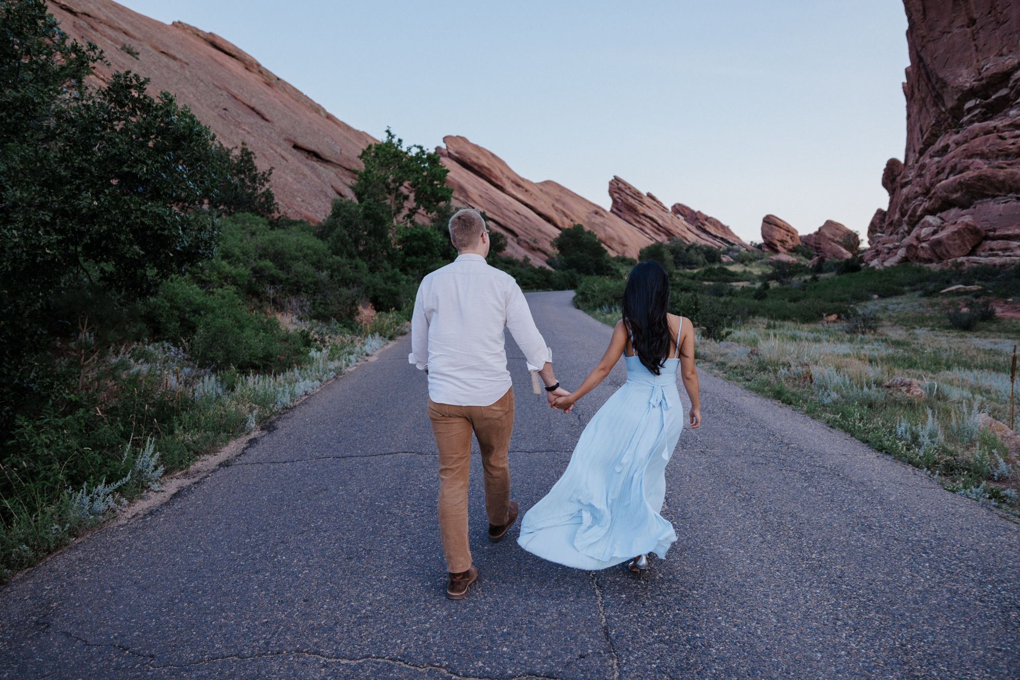 engaged couple wears pastel colors for engagement outfit at red rocks park.