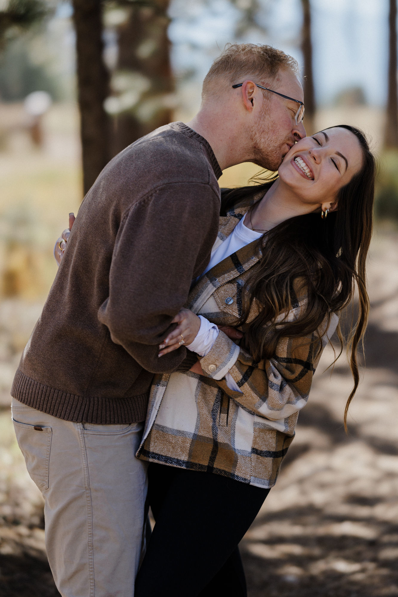 engaged couple wears casual outfits for engagement photos in colorado