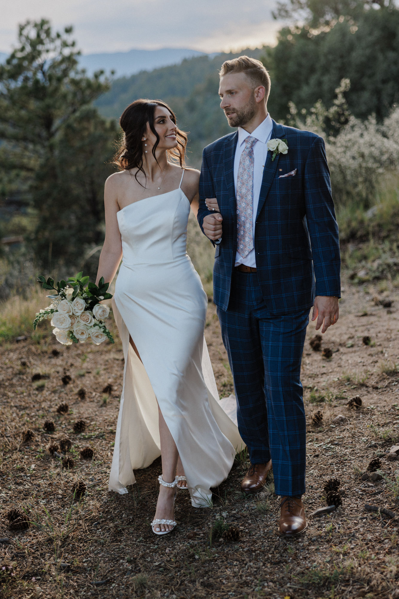 bride and groom walk through trail during airbnb micro wedding in colorado.