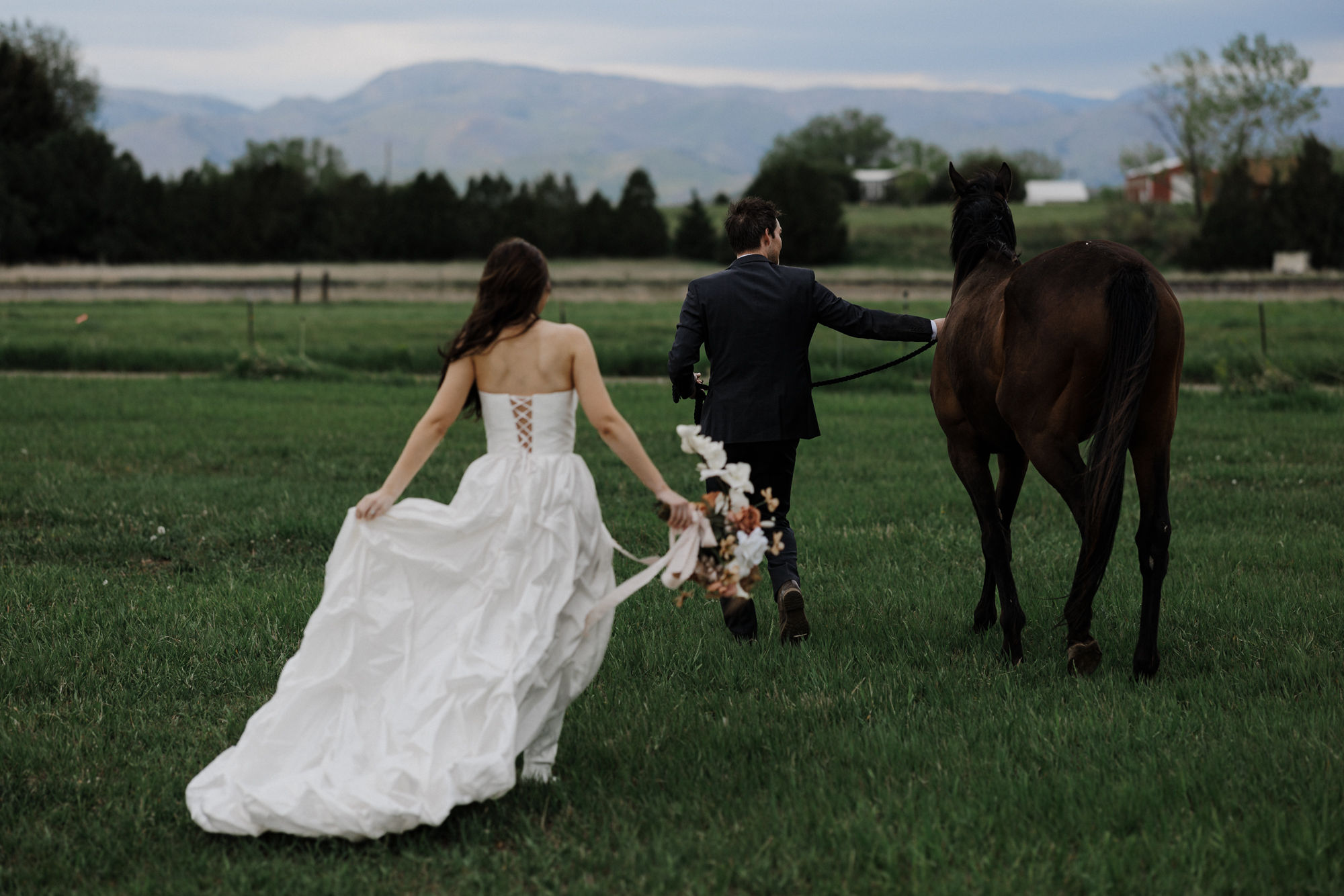 bride, groom, and horse pose for elopement photos after narrowing down the wedding guest list