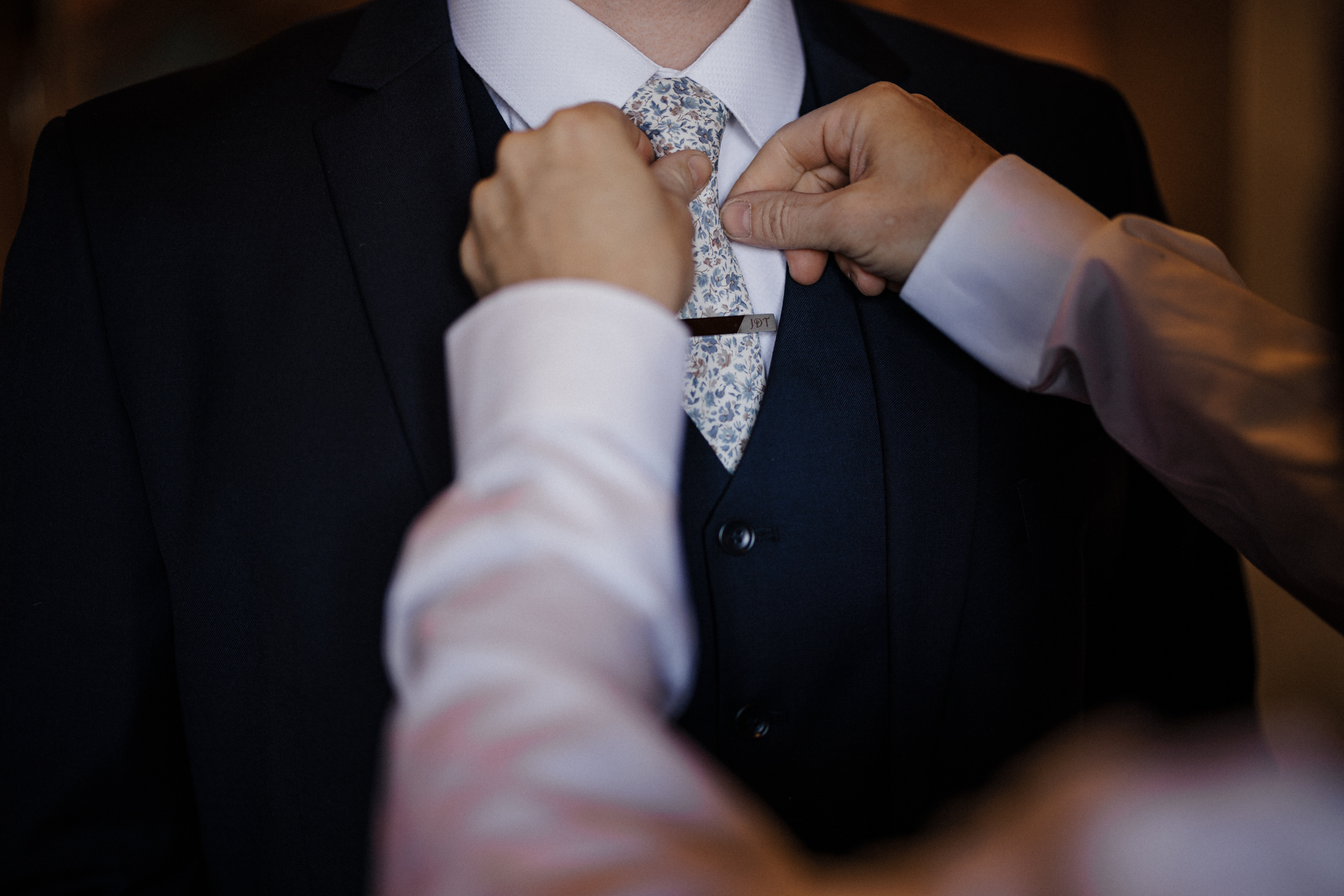 Father of the bride ties groom's tie during Colorado mountain micro wedding.