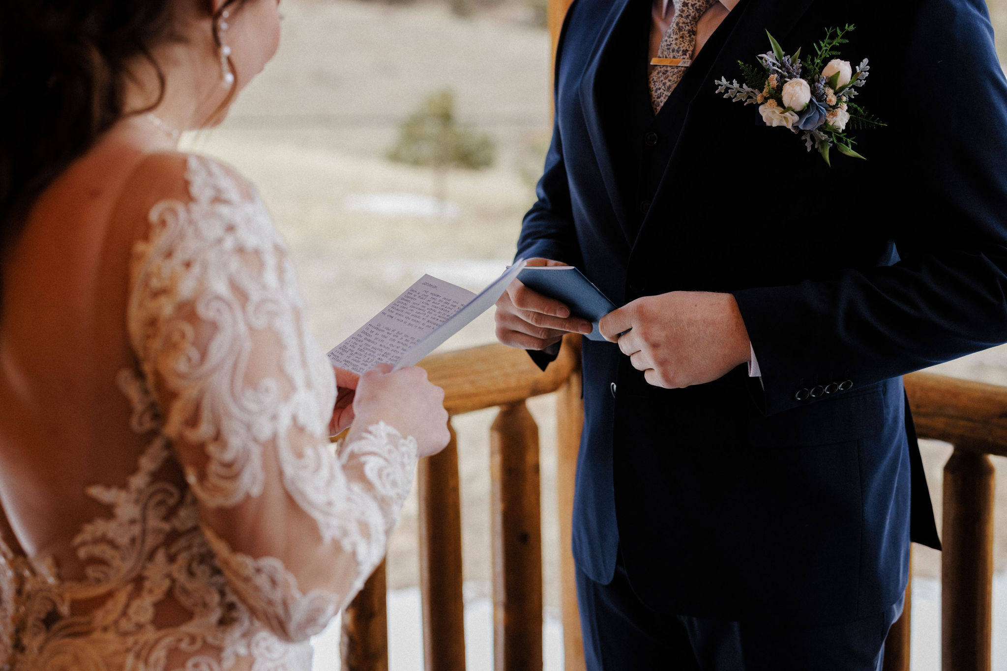 bride and groom hold wedding vow books at colorado airbnb