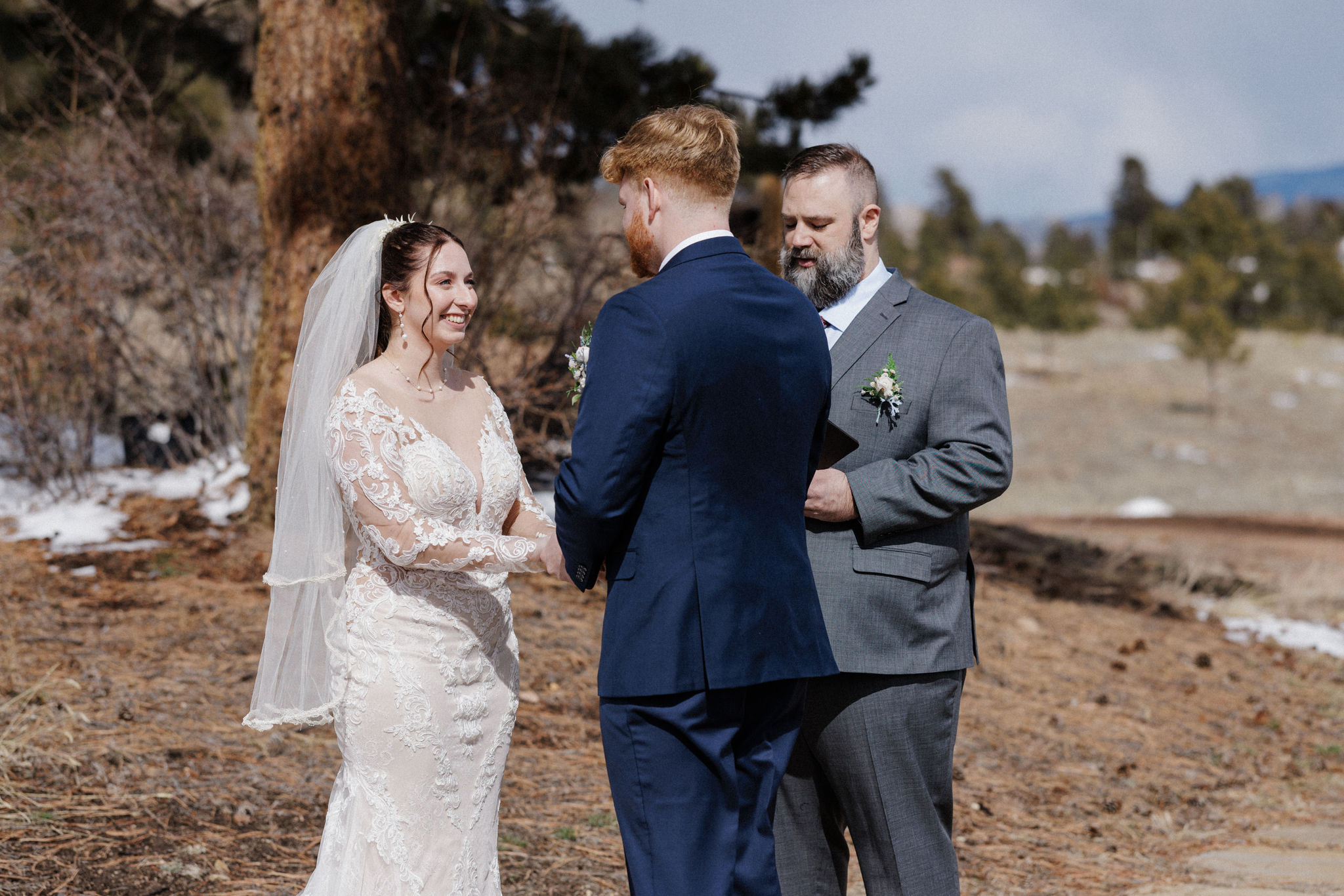 bride and groom smile during micro wedding ceremony outside in colorado