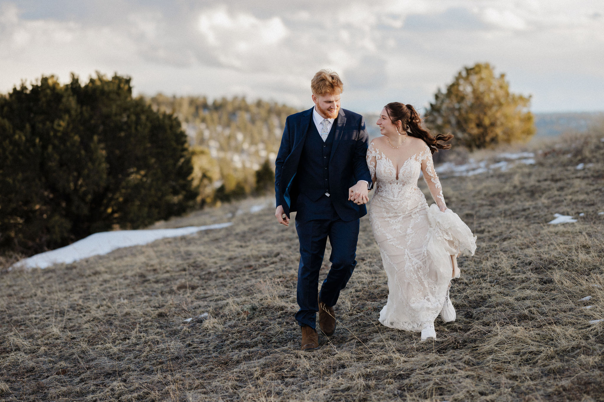 bride and groom walk along mountain during colorado micro wedding ceremony