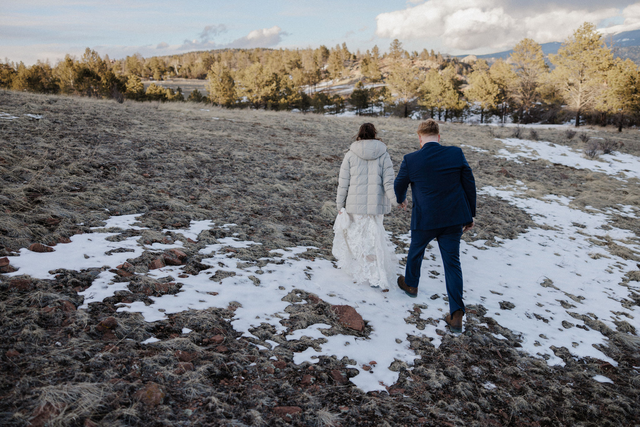 bride and groom walk along mountain during airbnb micro wedding
