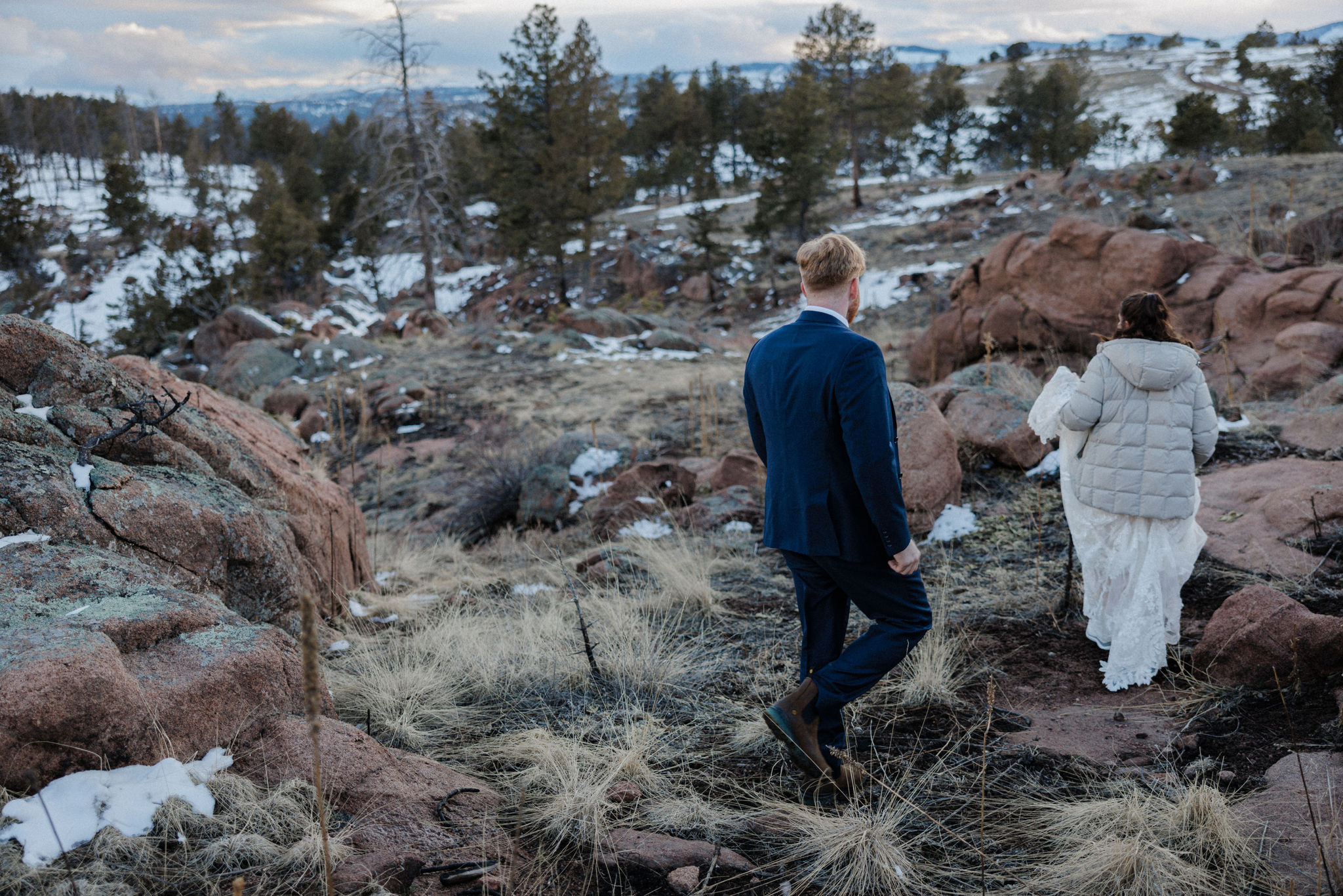 bride and groom walk along rocks at colorado airbnb wedding venue