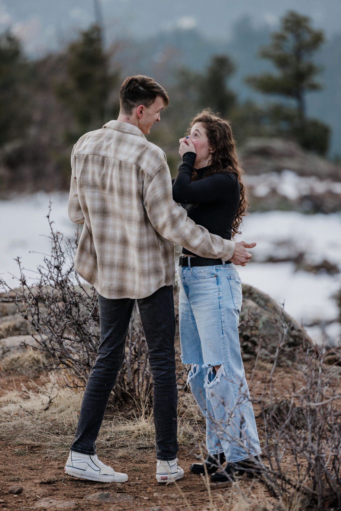 woman puts hand on her mouth after being proposed to in colorado 
