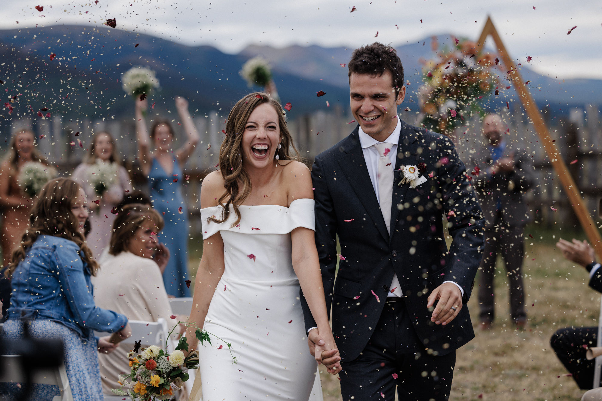 after both partners being involved in wedding planning, bride and groom smile as they walk away from micro wedding.