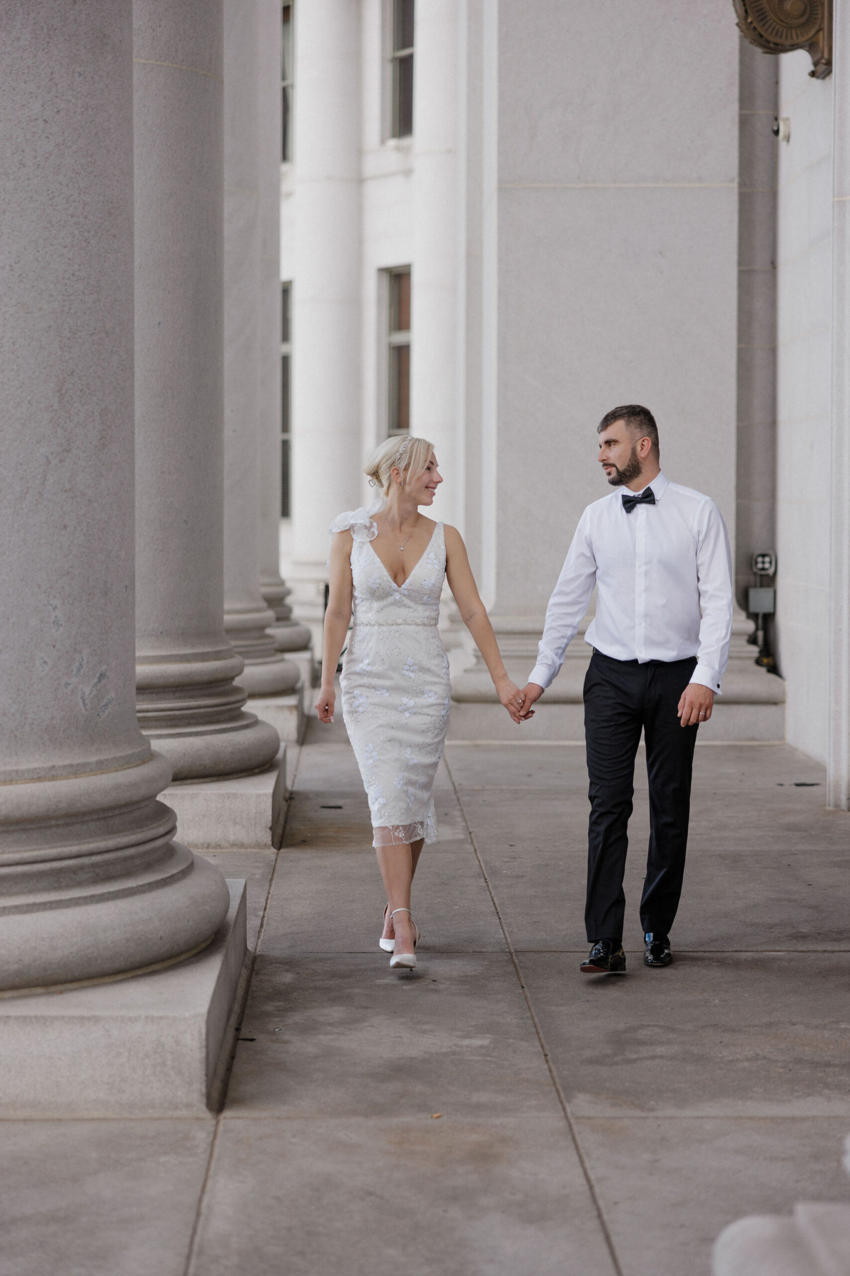 bride and groom hold hands and walk through courthouse during colorado elopement