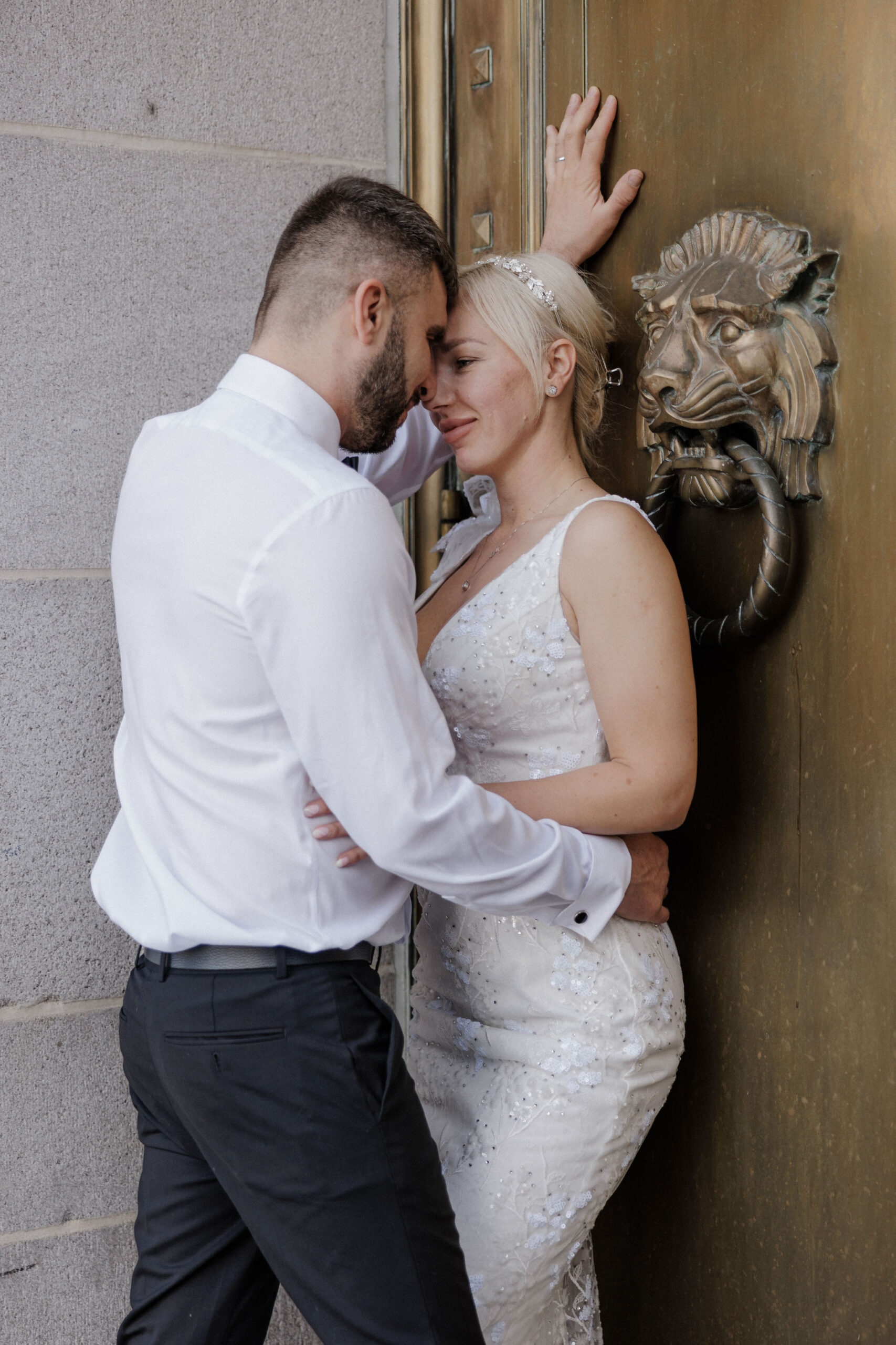 bride and groom lean up against gold door during colorado elopement