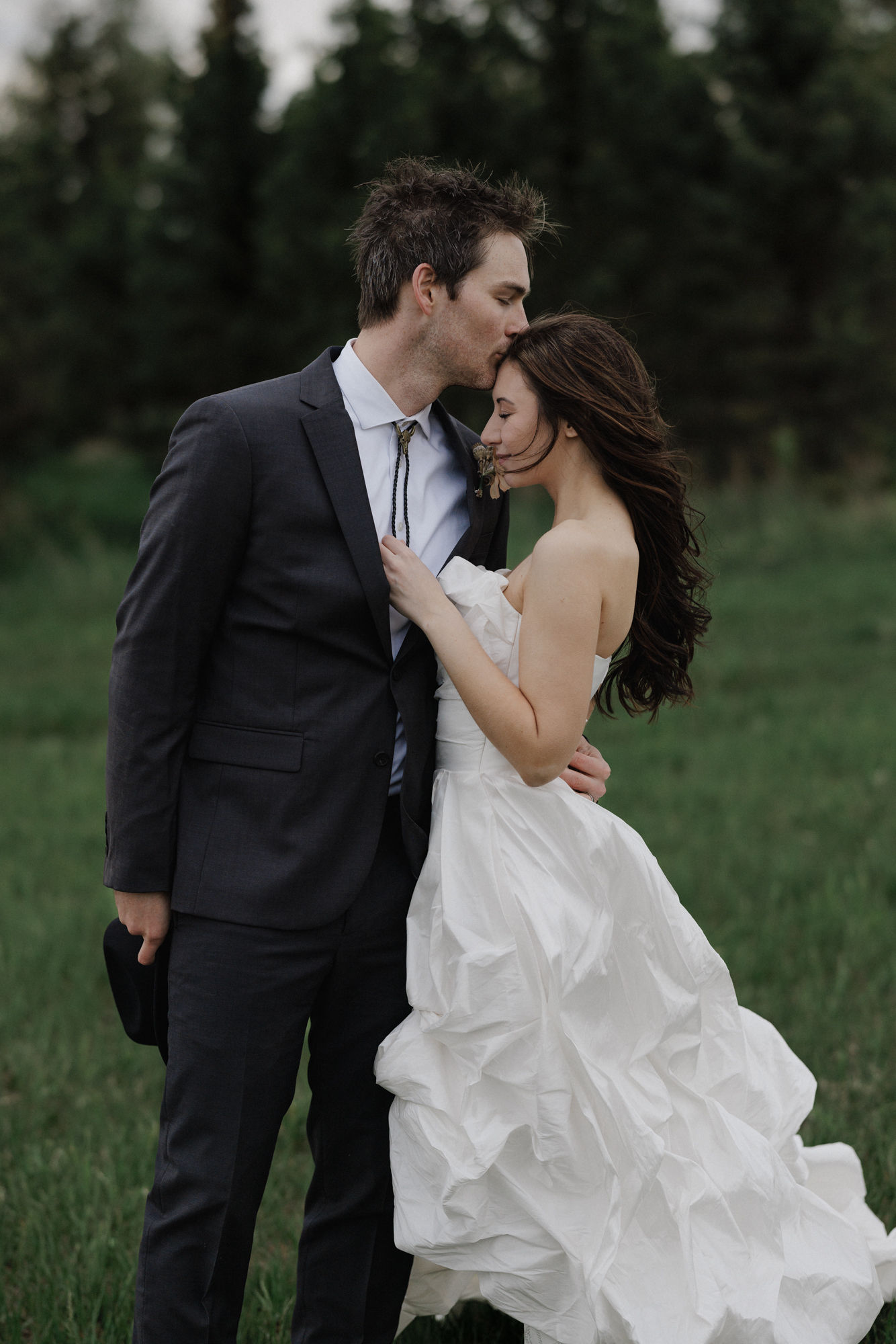 groom kisses brides head during wedding photos after finishing their planning checklist and timeline