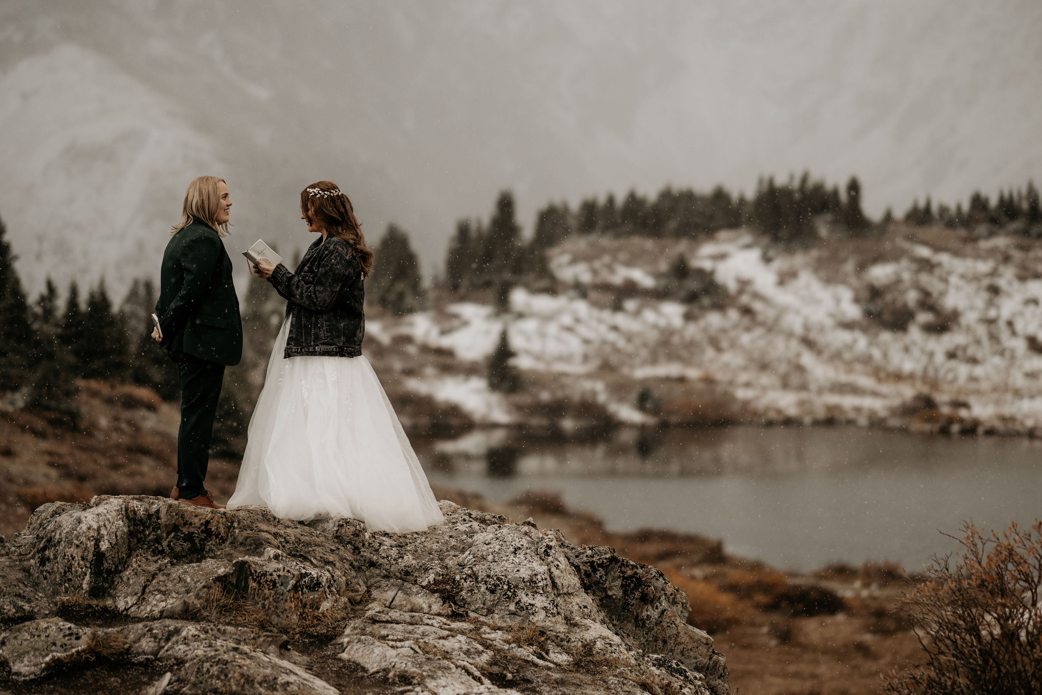 bride and bride stand on rock and say wedding vows during mountain elopement